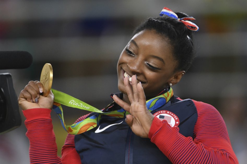 Cuatro, el número que muestra Simone Biles con su mano, las medallas de oro que ganó en los Olímpicos de Río 2016.