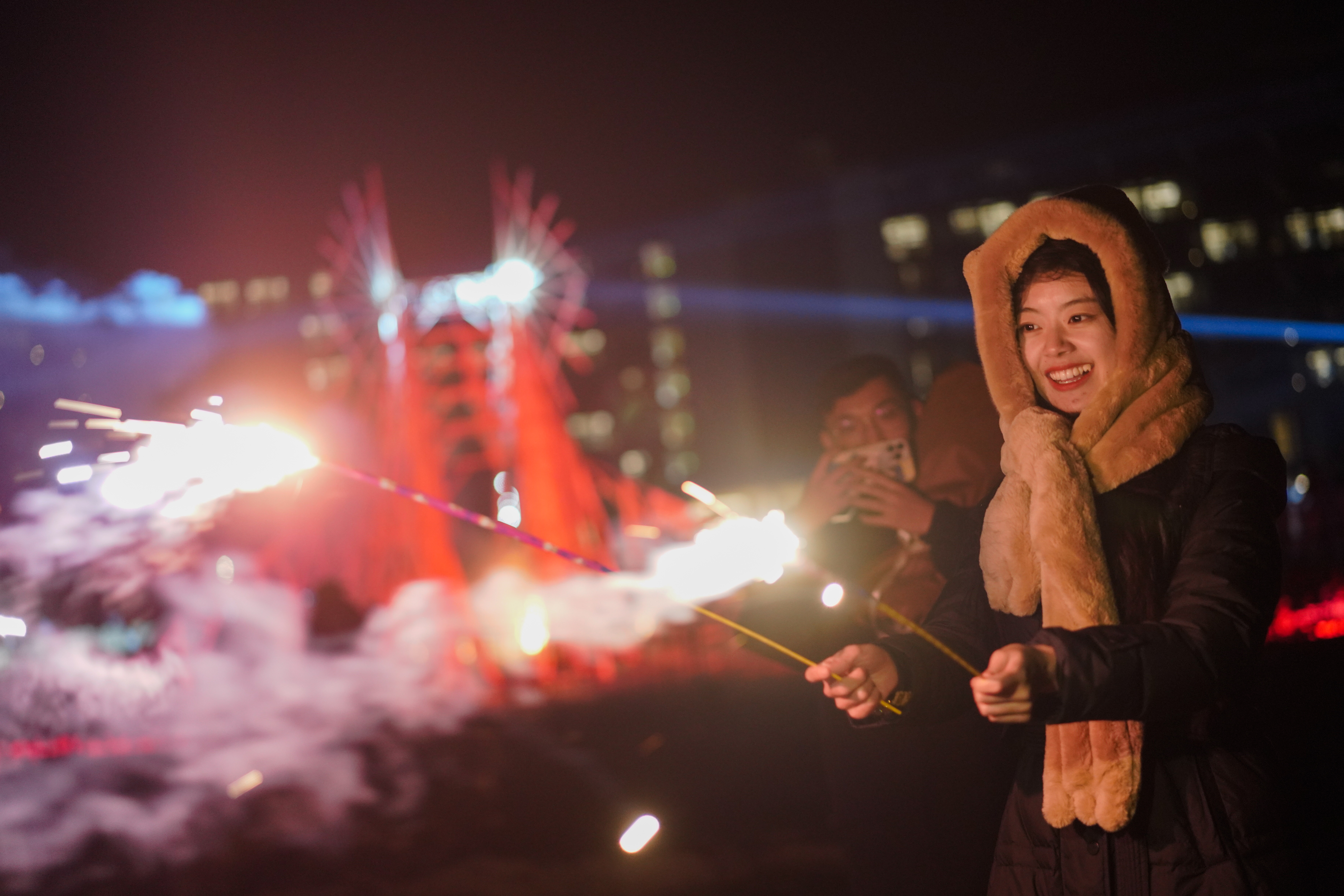 Qinhuangdao (China), 31/12/2022.- A woman celebrates new year with fireworks at Aranya resort in Qinhuangdao, China, 01 January 2023. After the cancelling of COVID-19 restrictions for inter-provincial travel, Chinese youth celebrated the new year during art festival held at Aranya resort from 31 December 2022 to 01 January 2023, which contain a series of concerts and performance art installations. (Incendio) EFE/EPA/WU HAO