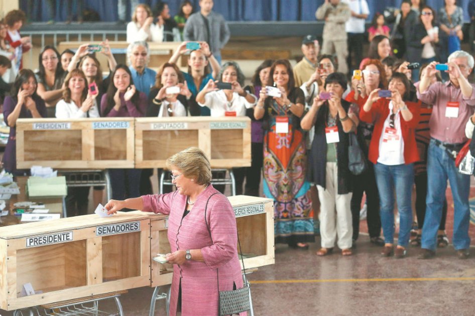 Michelle Bachelet, la candidata favorita en las presidenciales chilenas, deposita su voto  durante los comicios. /  EFE