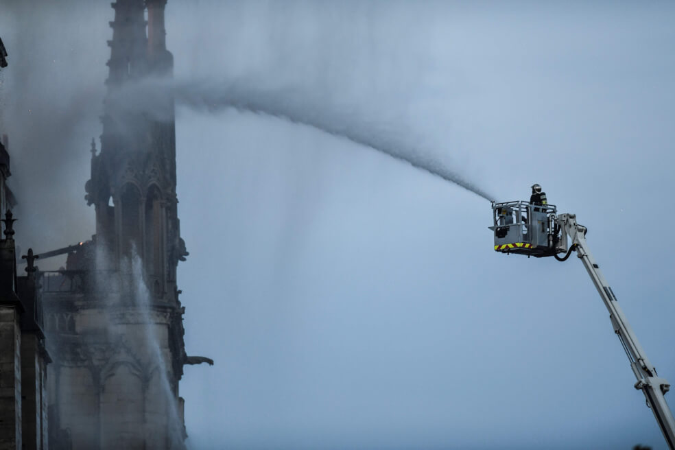 Un bombero intenta controlar las llamas que consumieron parte de la catedral de Notre Dame, en París, el lunes.  / AFP