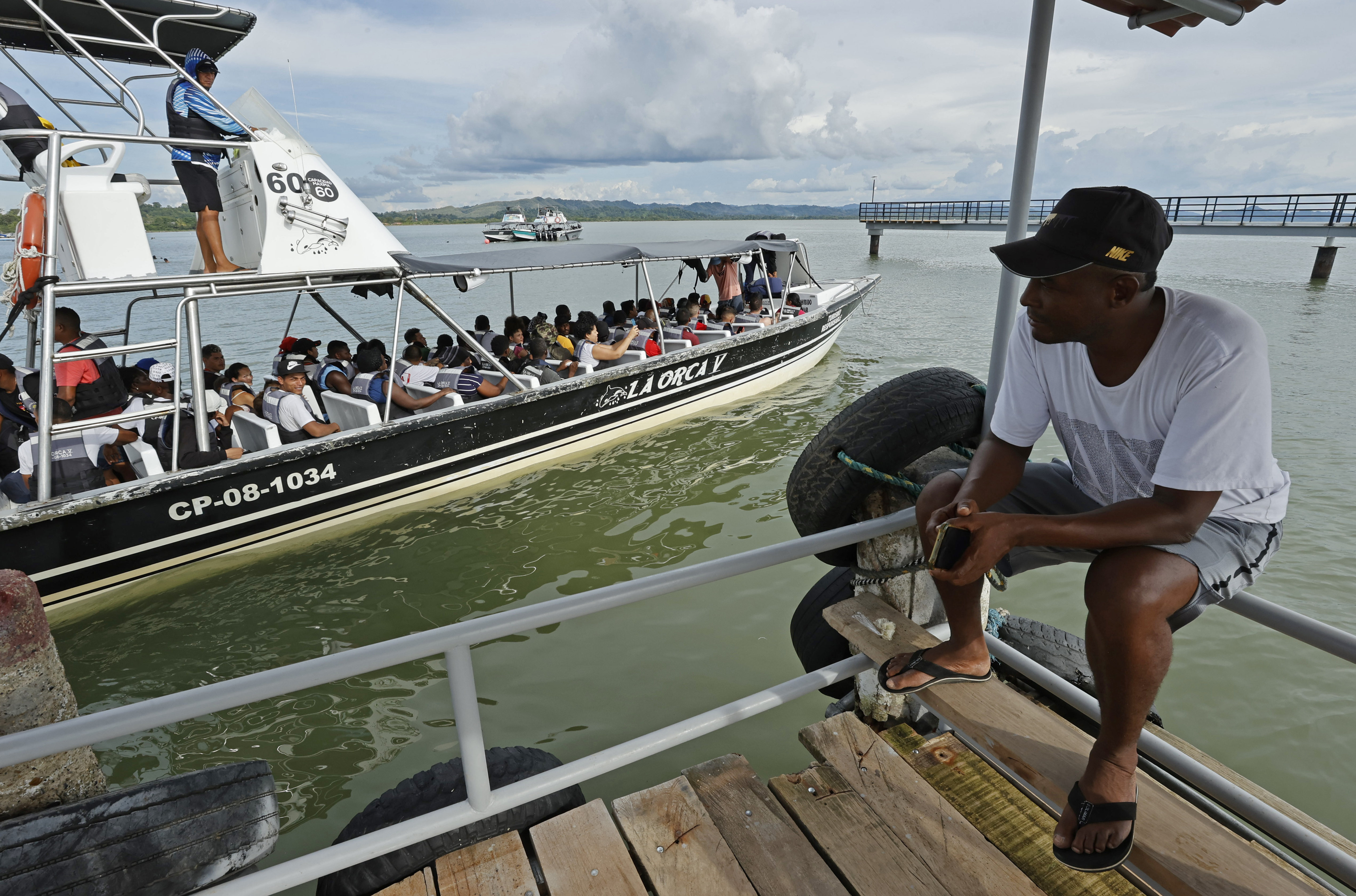 ACOMPAÑA CRÓNICA: COLOMBIA CRISIS MIGRATORIA. AME2685. NECOCLÍ (COLOMBIA), 07/10/2022.- Un hombre observa una lancha que parte con migrantes hacia la frontera con Panamá, el 6 de octubre de 2022, en Necocli (Colombia). En el pueblo colombiano de Necoclí ya se acostumbraron a que a diario cientos de personas acampen en sus playas a la espera de coger las lanchas que los llevan a la frontera de Panamá en una travesía migratoria hacia EE.UU. que crece cada día y amenaza con "explotar". EFE/ Mauricio Dueñas Castañeda