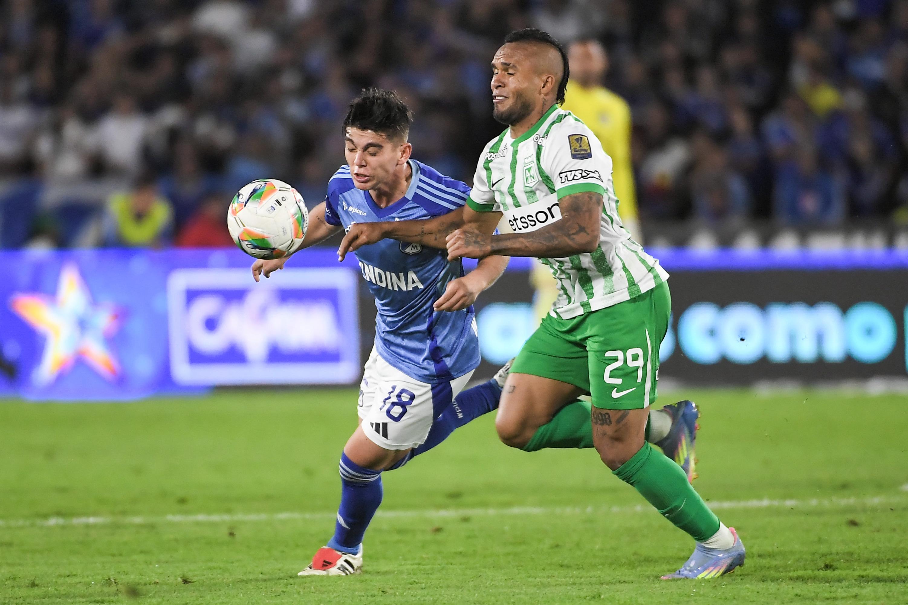 Daniel Ruiz (Millonarios) y Andrés Sarmiento luchan por una pelota.