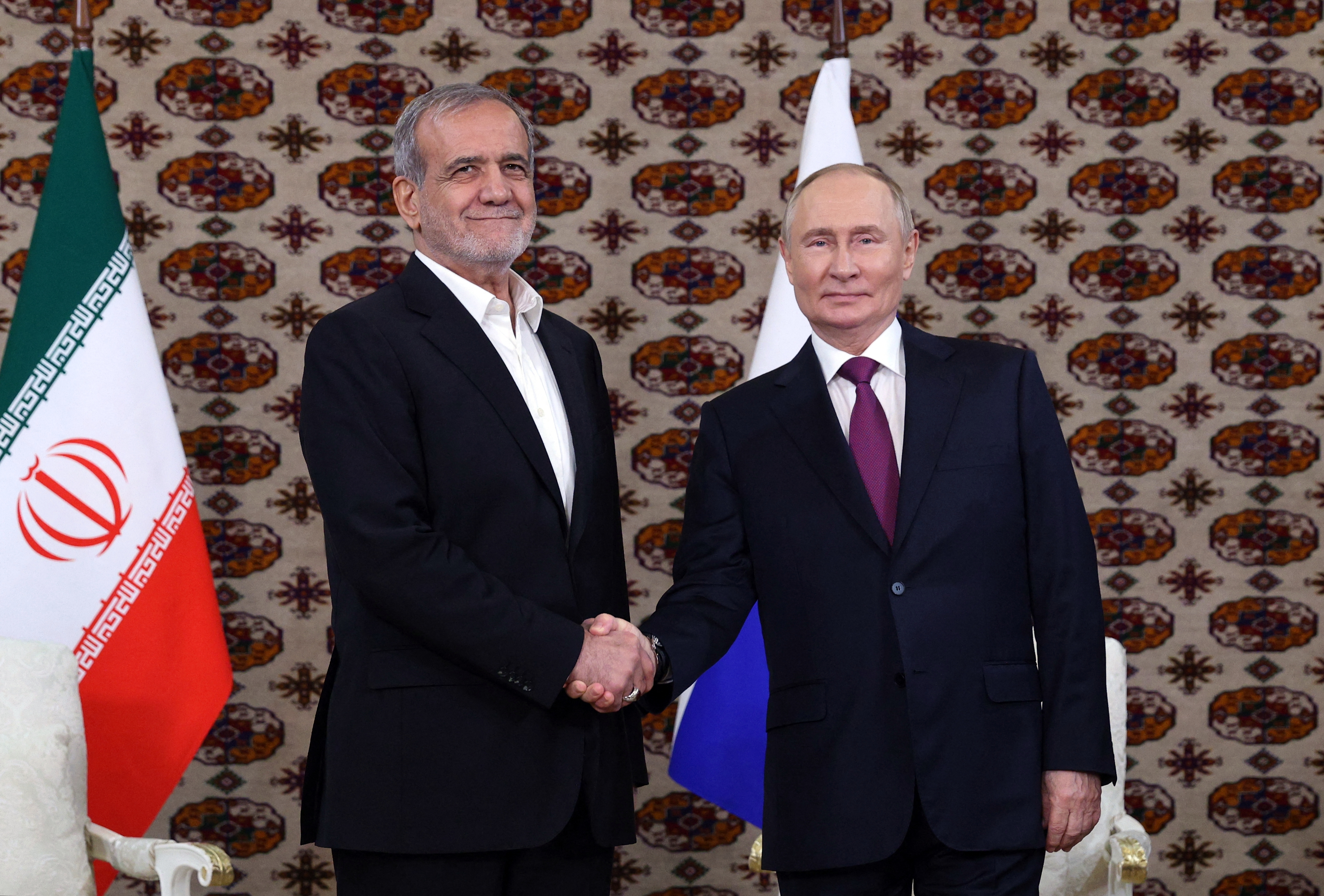 TOPSHOT - In this pool photograph distributed by the Russian state agency Sputnik, Russia's President Vladimir Putin meets with Iran's President Masoud Pezeshkian on the sidelines of an international forum "Interrelation of times and civilizations - basis of peace and development" dedicated to the 300th anniversary of poet Magtymguly Fragi's birthday in Ashgabat on October 11, 2024. (Photo by Alexander SHCHERBAK / POOL / AFP)