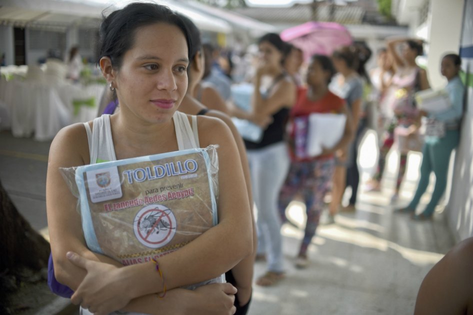 Una mujer embarazada sostiene un mosquitero, entregado por el Ministerio de Salud para protegerse de la infección por virus Zika en Cali, Colombia. / AFP