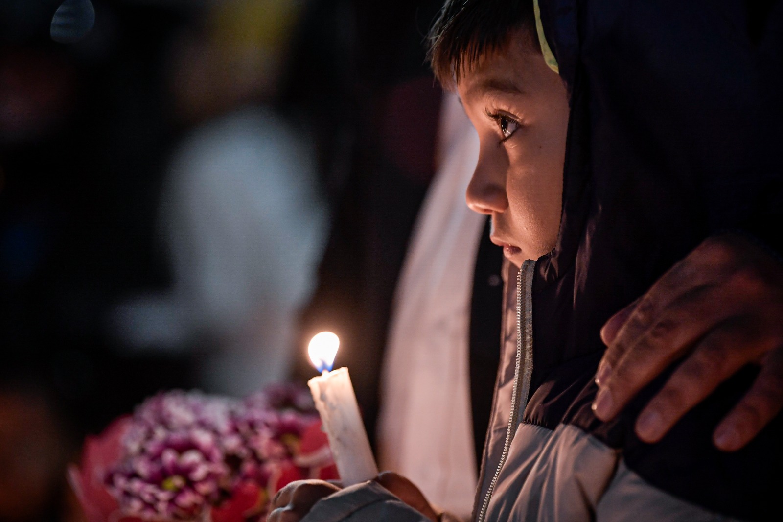 Niño es llevado por sus acudientes a participar de la velatón.
