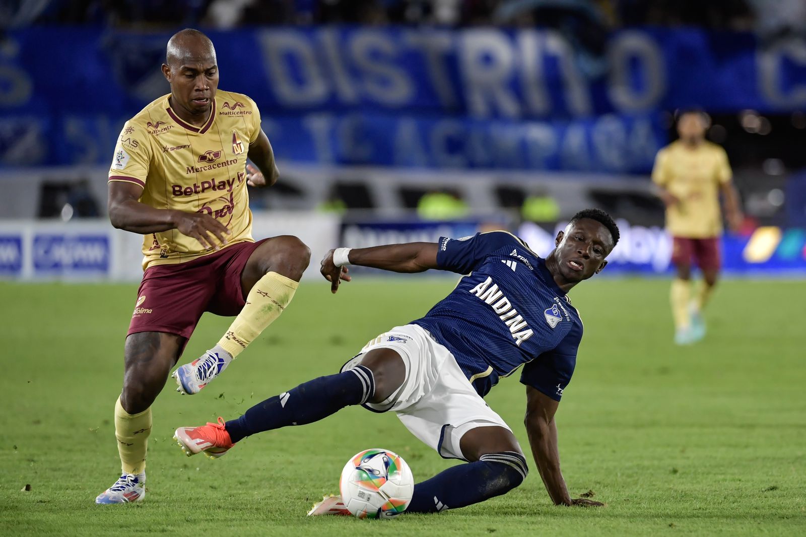 Junior Hernández (Tolima) disputa una pelota con Jhon Emerson Córdoba, de Millonarios.