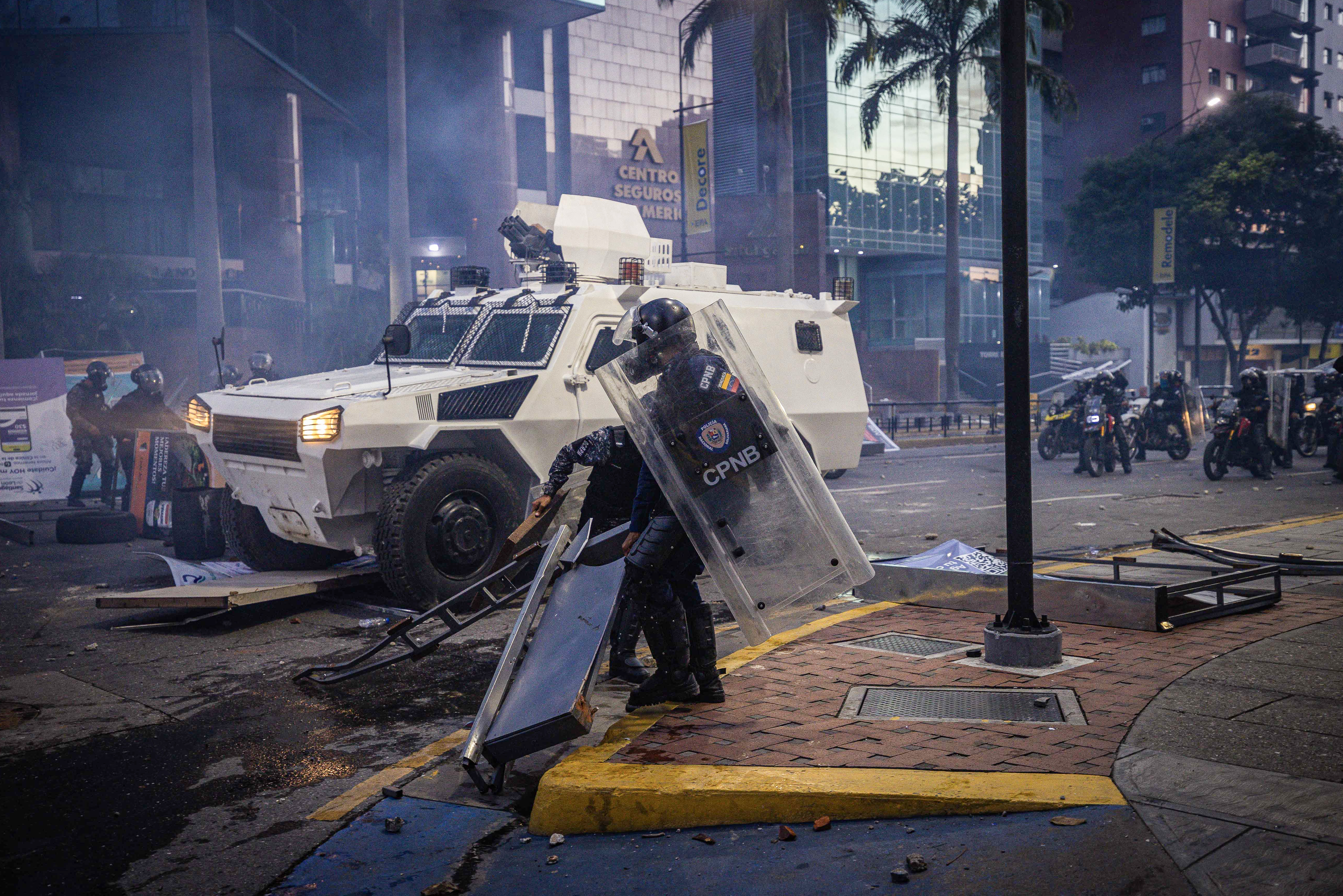 AME6327. CARACAS (VENEZUELA), 29/07/2024.- Integrantes de la Guardia Nacional Bolivariana (GNB) se enfrentan a manifestantes por los resultados de las elecciones presidenciales este lunes, en Caracas (Venezuela). Miles de ciudadanos han salido para protestar contra los resultados anunciados por el Consejo Nacional Electoral (CNE), que otorga al presidente Maduro el 51,2 % de los votos, un dato cuestionado por la oposición y por buena parte de la comunidad internacional. EFE/ Henry Chirinos