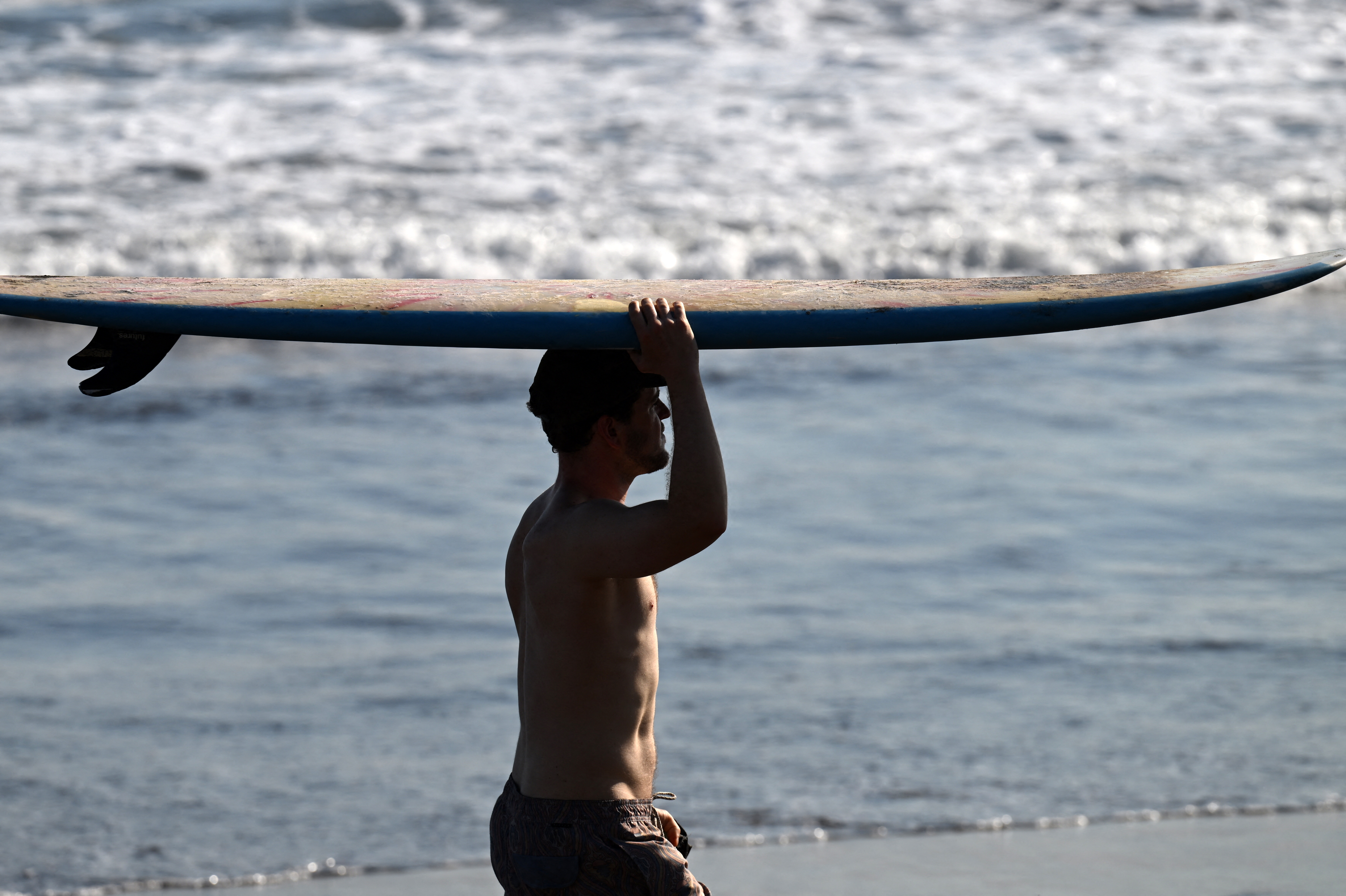 Un turista asiste a clases de surf en la playa El Tunco, en La Libertad, El Salvador.