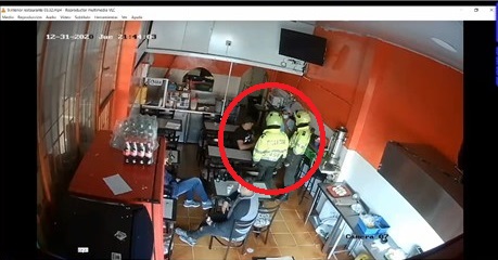 El comerciante junto a los patrulleros en una cafetería.