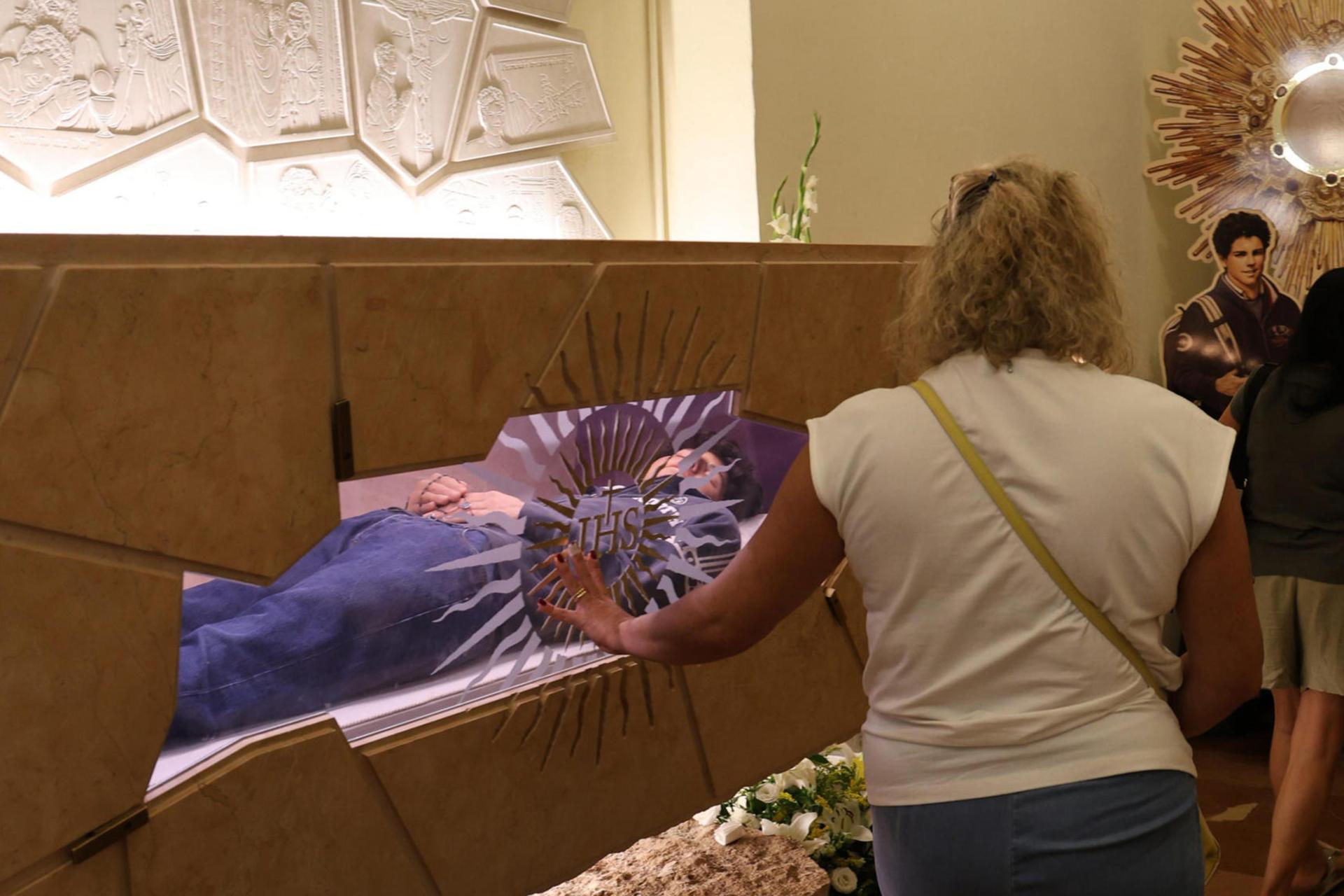 Assisi (Italy), 07/09/2025.- A faithful looks at the body of Saint Carlo Acutis at the Sanctuary of the Renunciation in Assisi, Italy, 07 September 2025. Carlo Acutis, an Italian teenager who died in 2006, will be canonized by Pope Leo XIV in a ceremony at the Vatican, becoming the first millennial saint. (Papa, Italia) EFE/EPA/GIANLUIGI BASILIETTI
