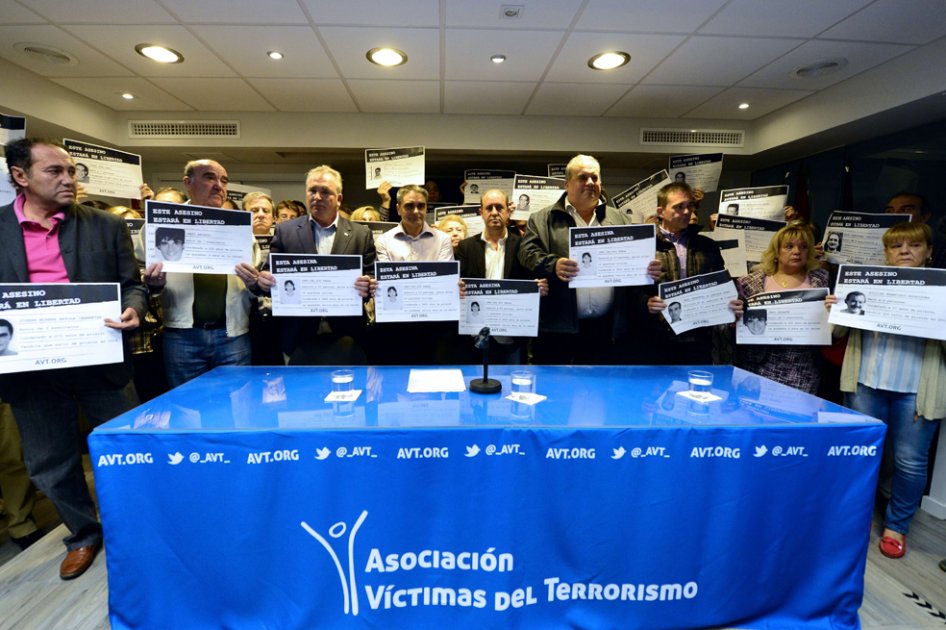 Miembros de la asociación de víctimas del terrorismo protestan en contra del fallo que daría libertad a varios presos de ETA. “Este asesino estará en libertad” señalan los carteles./ EFE
