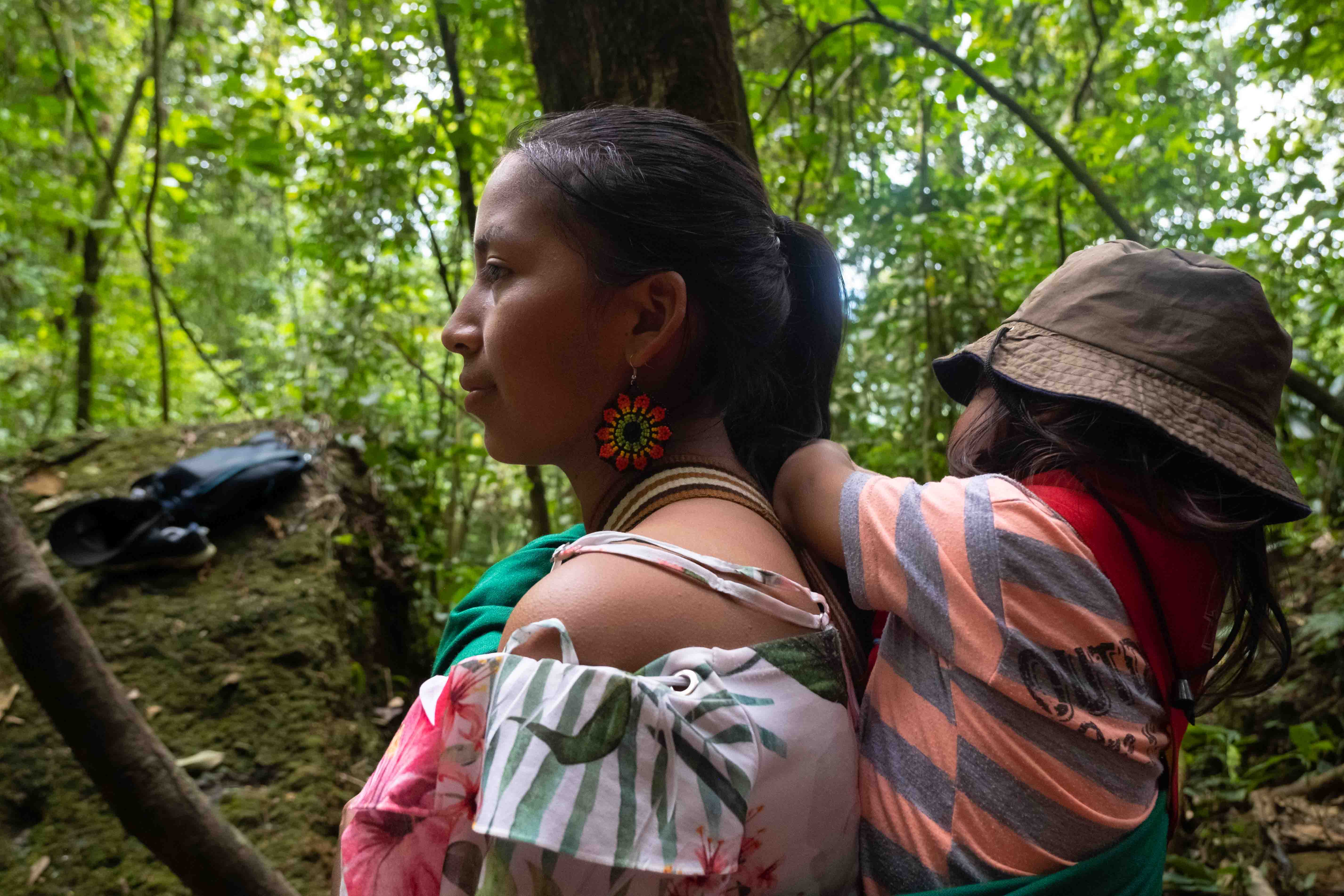Una mujer indígena del Putumayo lleva a su hijo por el sendero sagrado de la Casa de Encuentro Chagra de la Vida. Mocoa, Putumayo.