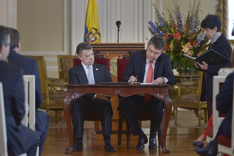 El presidente, Juan Manuel Santos, acompañado del ministro de Hacienda, Mauricio Cárdenas, en la firma de las nuevas leyes. / Presidencia