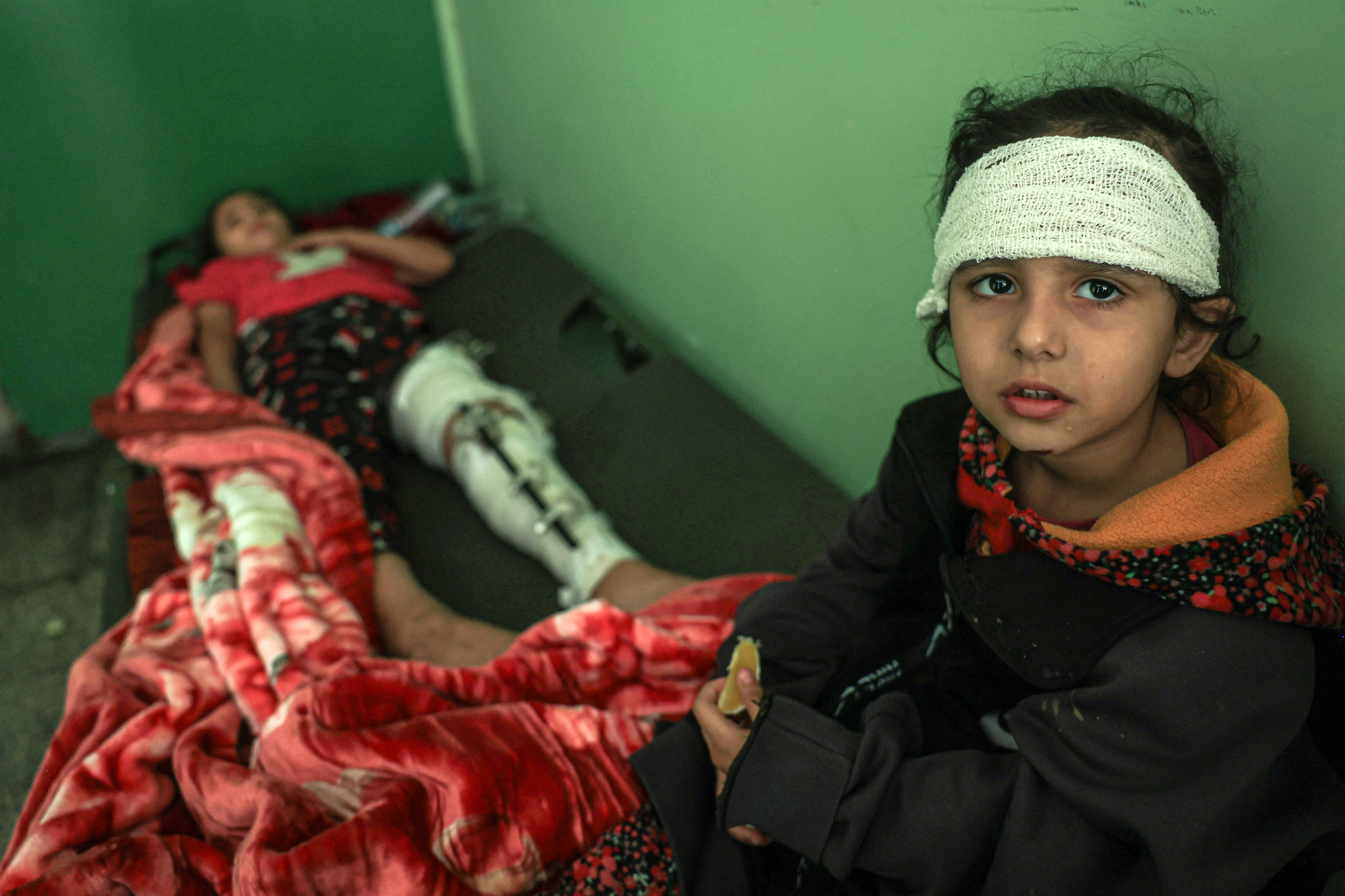 Hoda Al-Madhoun, de 5 años (derecha), y Nada, de 10, yacen heridos en un aula de la escuela Ras Al-Naqoura en Khan Yunis, en el sur de la Franja de Gaza, tras ser trasladados desde el Hospital de Indonesia en el norte.