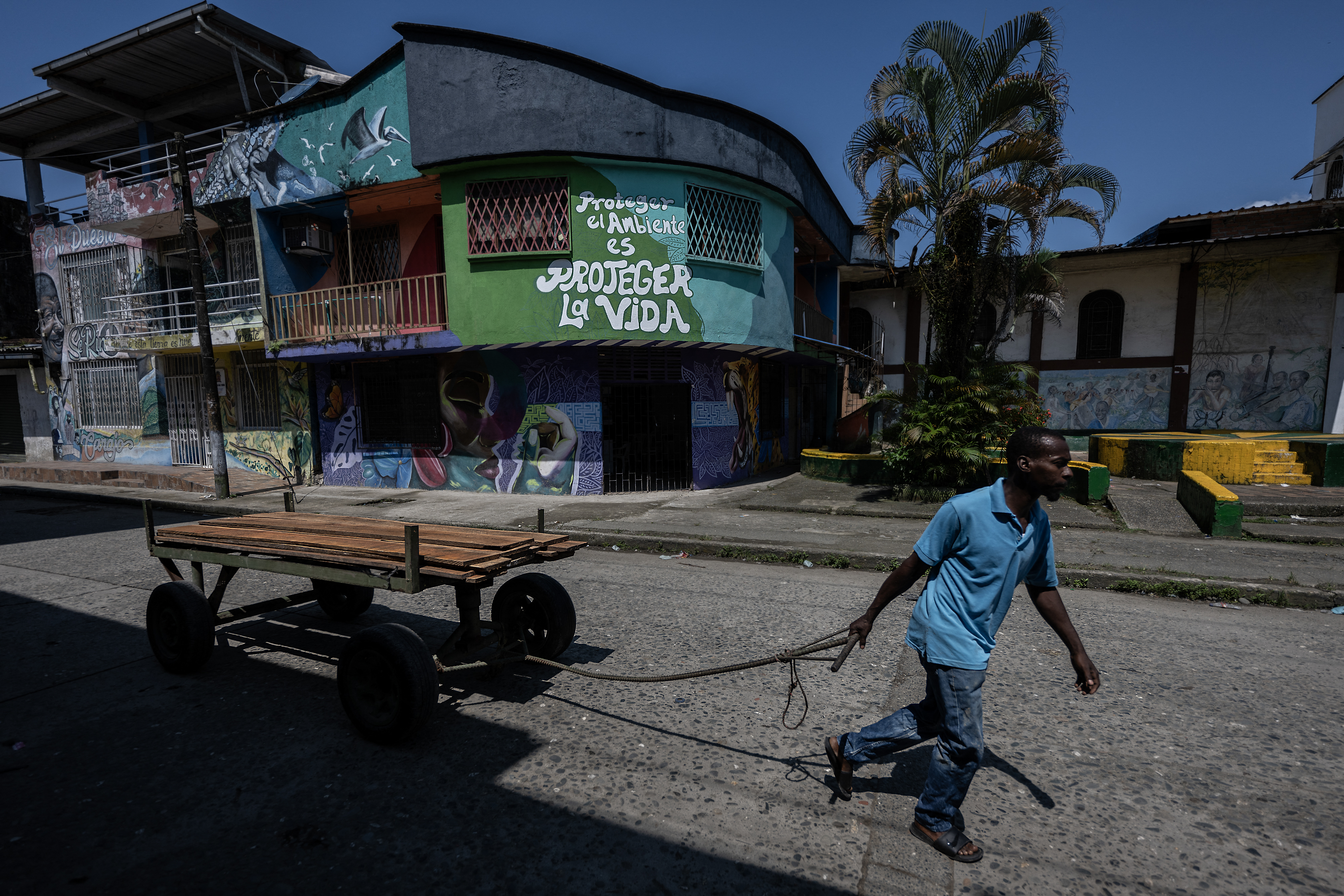 A man pulls a cart loaded with wood on a street in Buenaventura, Valle del Cauca department, Colombia, on September 4, 2024.