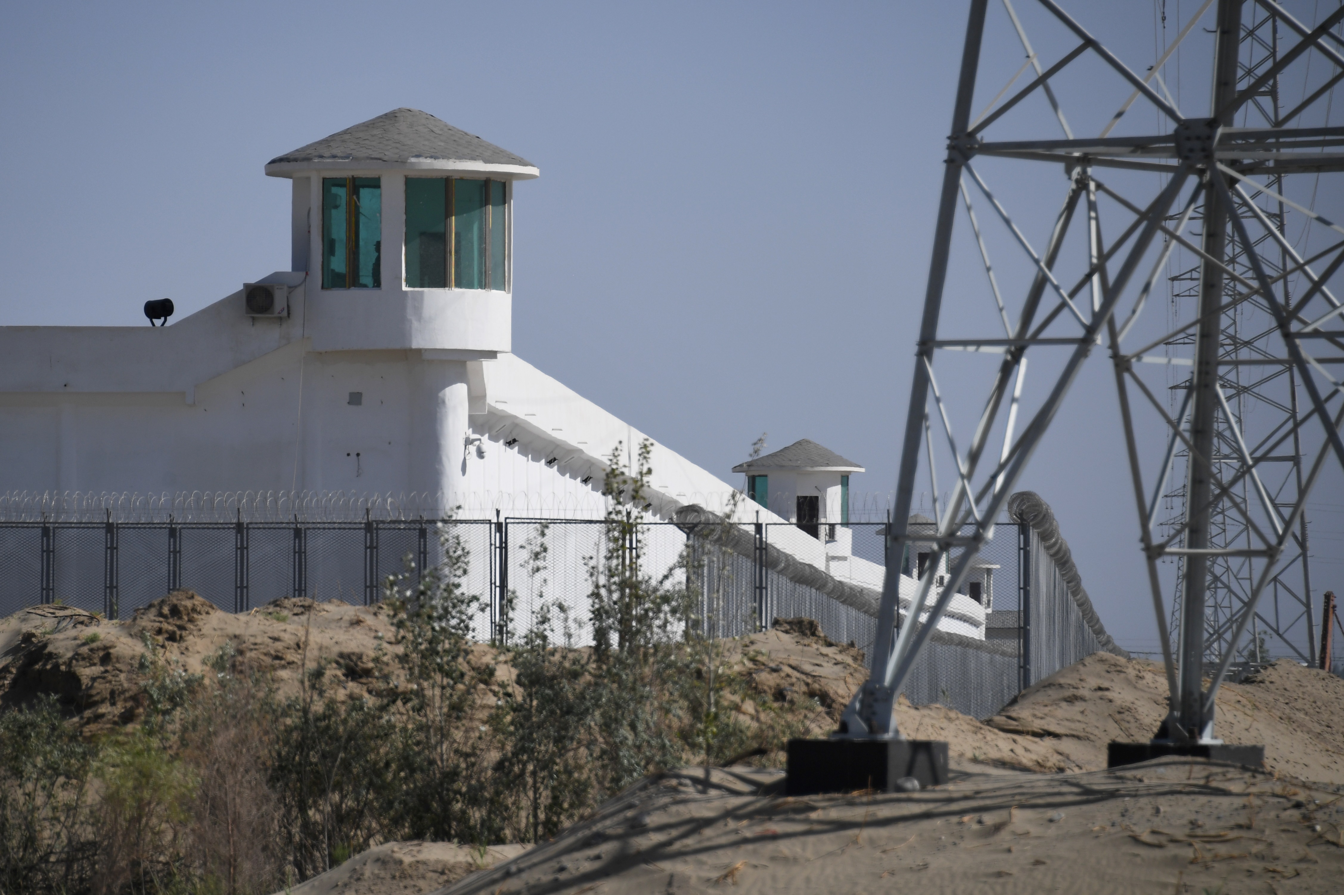 Esta foto tomada el 30 de mayo de 2019 muestra torres de vigilancia en una instalación de alta seguridad cerca de lo que se cree que es un campo de reeducación donde están detenidas en su mayoría minorías étnicas musulmanas, en las afueras de Hotan, en la región noroeste de Xinjiang de China / AFP