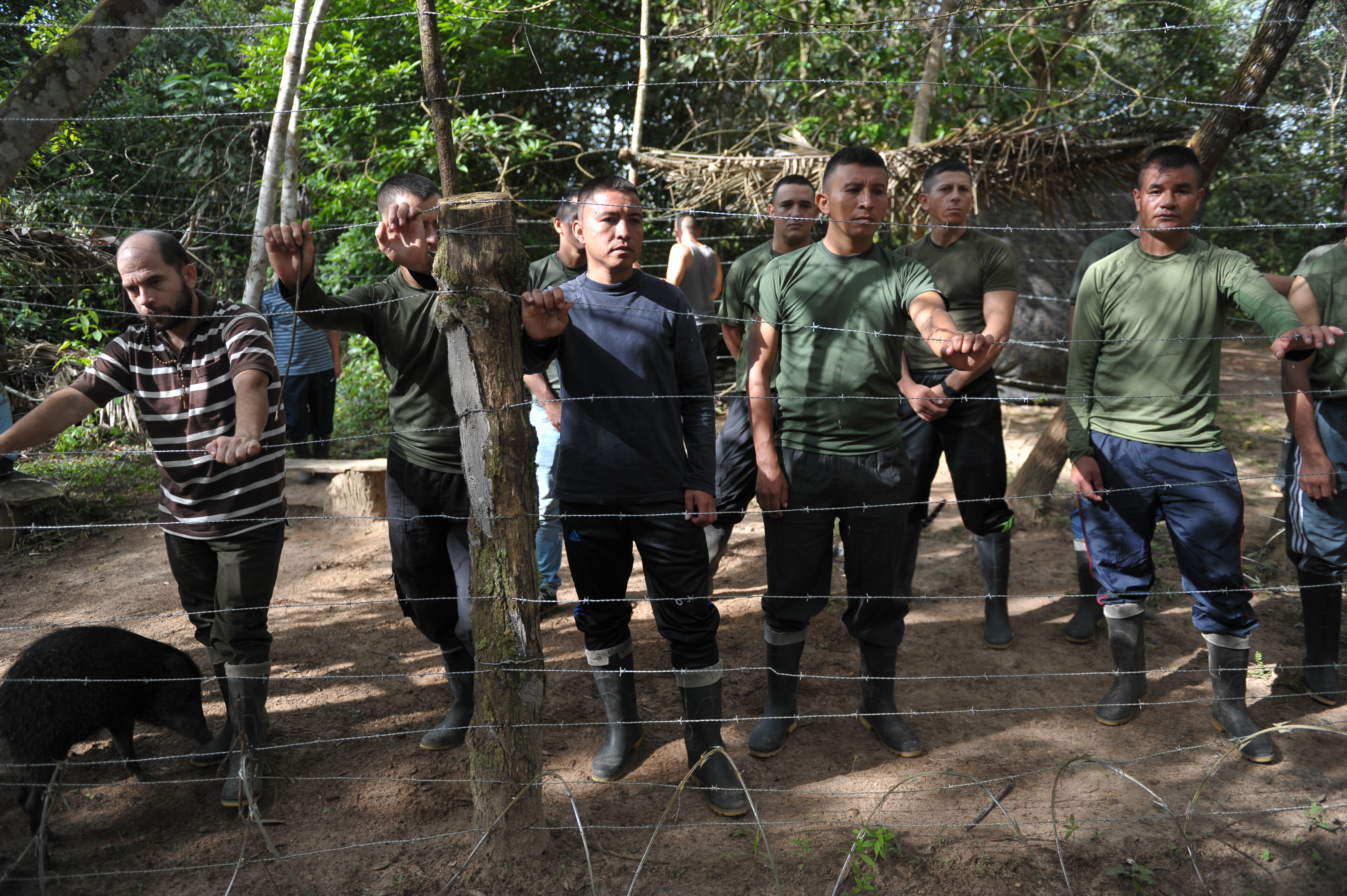 Hombres detrás de una red de púas, simulando el secuestro.