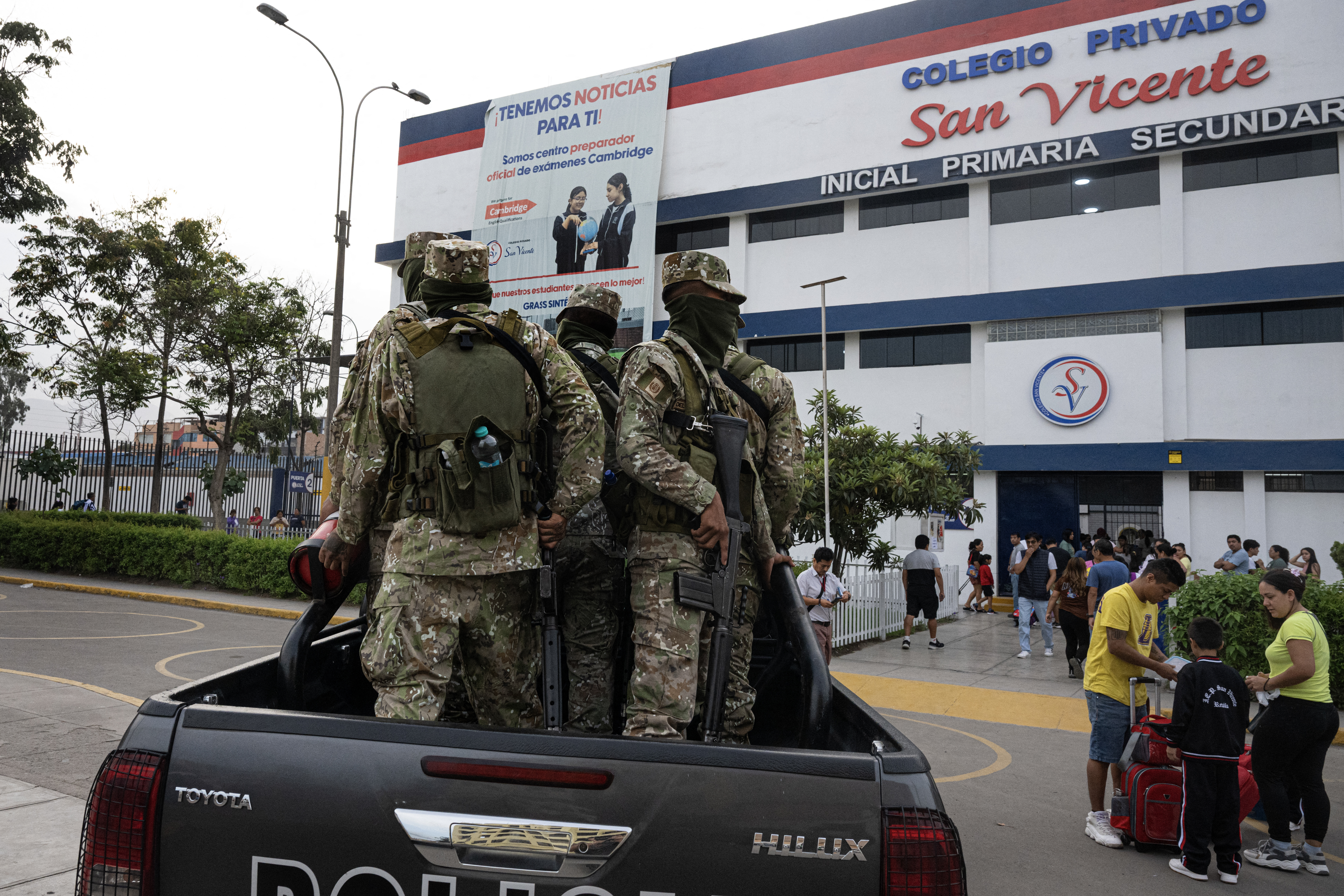 Members of the Peruvian army stand guard as parents drop off their children at the private San Vicente School, that was victim of extortion, in Lima on April 2, 2025.