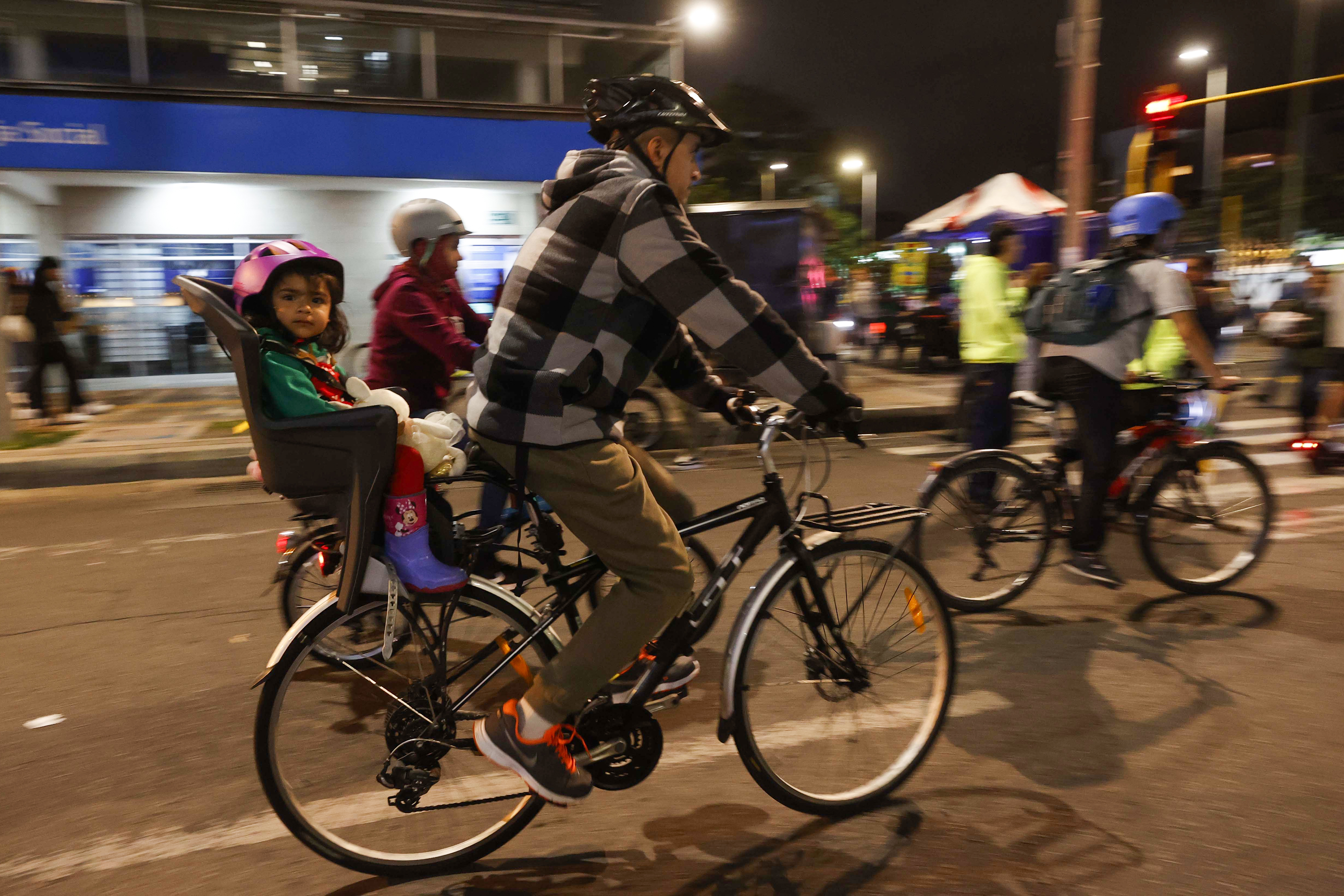 AME5151. BOGOTÁ (COLOMBIA), 13/12/2024.- Personas se movilizan en bicicleta este jueves, durante una jornada de ciclovía nocturna en Bogotá (Colombia). Los bogotanos podrán recorrer más de los 90 kilómetros de vías habilitadas y disfrutar el alumbrado navideño y actividades recreativas en puntos estratégicos. EFE/ Mauricio Dueñas Castañeda