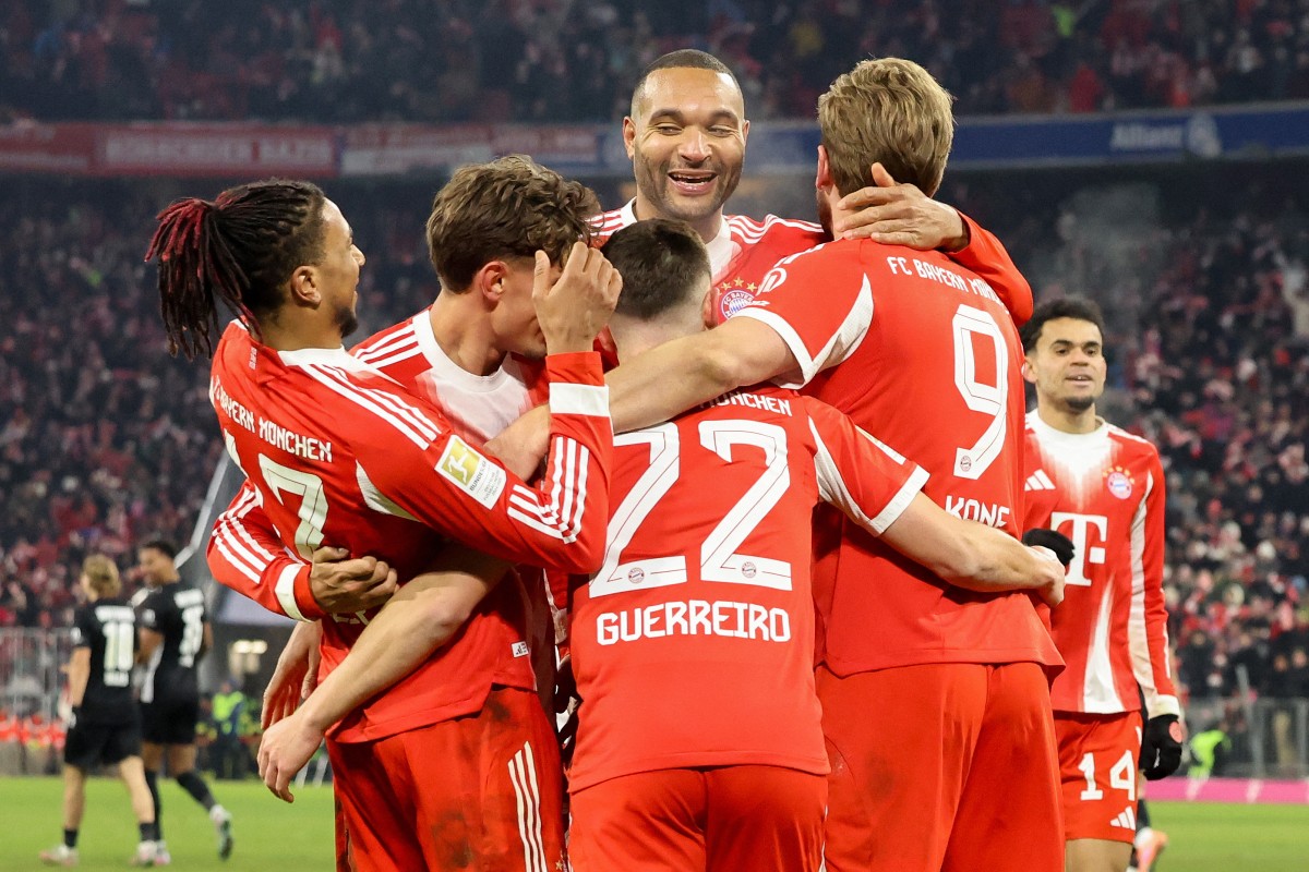 TOPSHOT - Bayern Munich's English forward #09 Harry Kane (R) celebrates scoring the 6-1 goal with his teammates during the German first division Bundesliga football match between FC Bayern Munich and VfL Wolfsburg in Munich, southern Germany, on January 11, 2026. (Photo by Alexandra BEIER / AFP) / DFL REGULATIONS PROHIBIT ANY USE OF PHOTOGRAPHS AS IMAGE SEQUENCES AND/OR QUASI-VIDEO