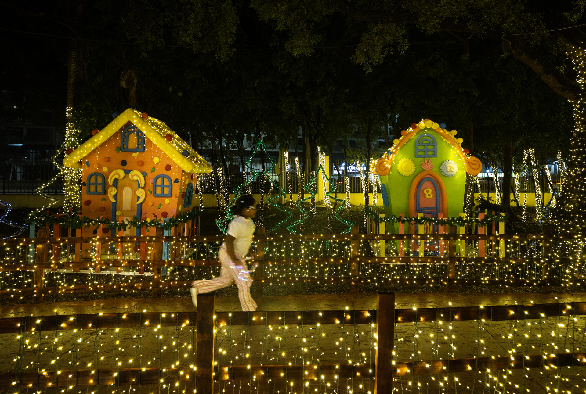 AME234. SANTO DOMINGO (REPÚBLICA DOMINICANA), 23/12/2025.- Una niña corre en el parque temático Villa Navidad este lunes, en Santo Domingo (República Dominicana). EFE/ Orlando Barría