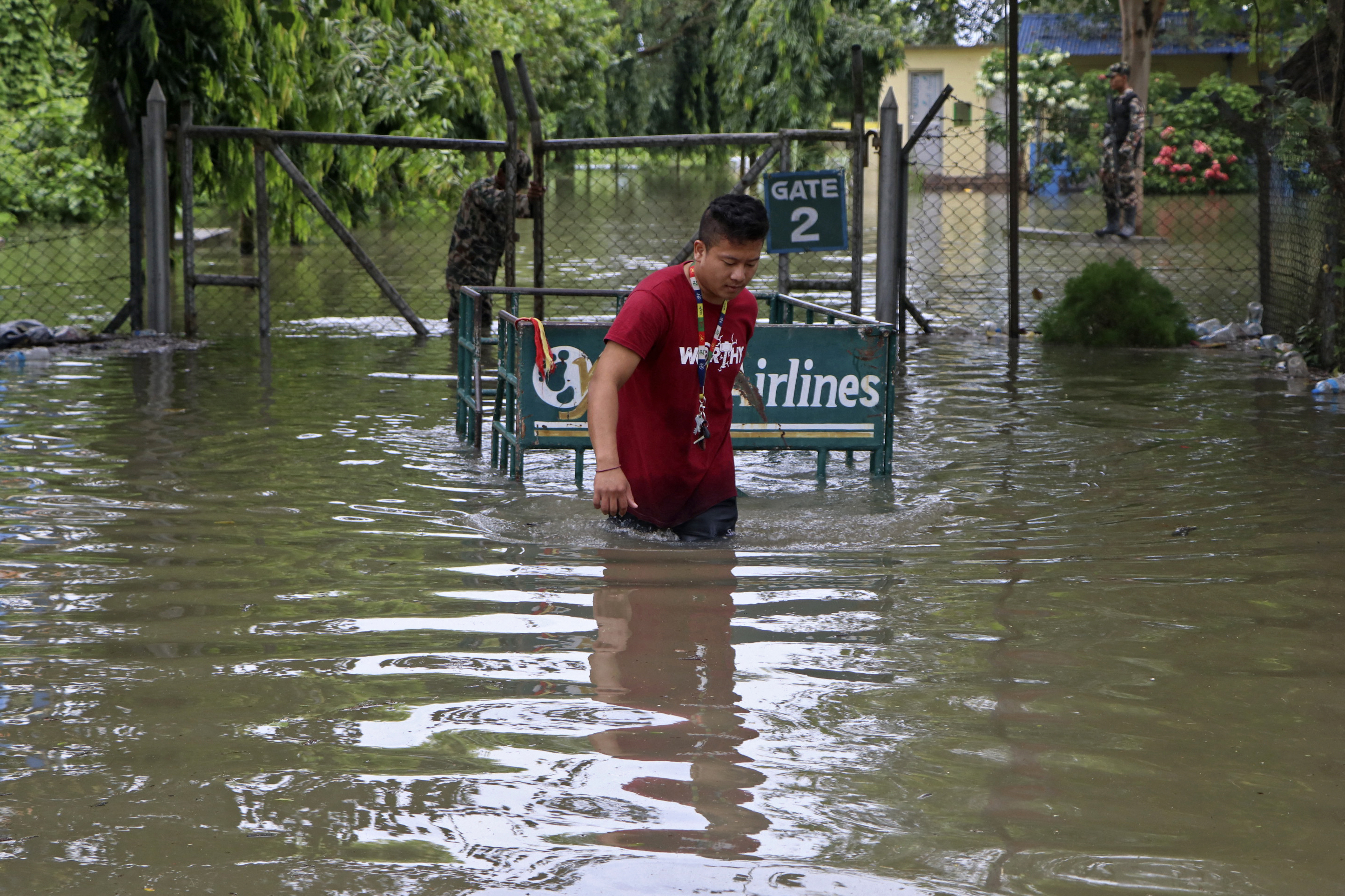 An airlines employee pulls a trolly through the premises of a flooded domestic airport after heavy rains in Biratnagar on October 20, 2021, as the death toll from days of flooding and landslides in India and Nepal crossed 100. (Photo by Lila Ballav Ghimire / AFP)