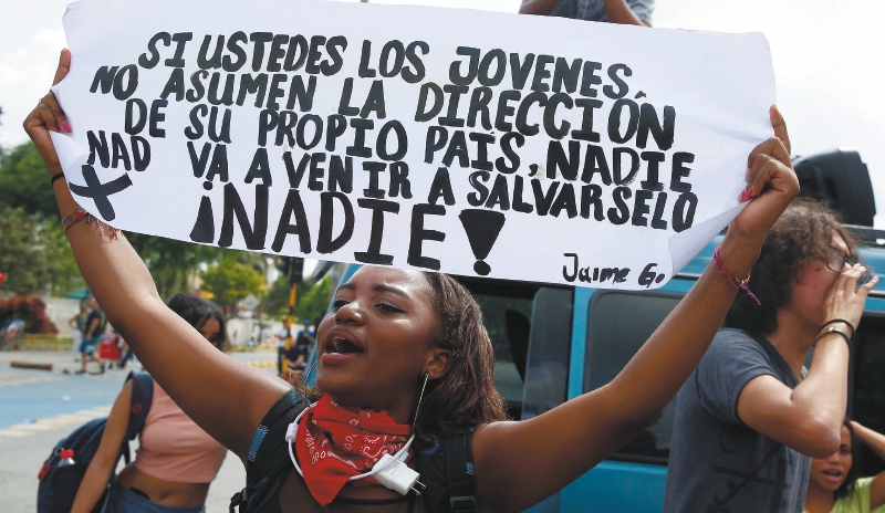 AME2691. CALI (COLOMBIA), 04/12/2019.- Una estudiante de la universidad del Valle sostiene un cartel este miÈrcoles durante la tercera jornada de paro nacional en rechazo al gobierno del Iv·n Duque, en Cali (Colombia). EFE/ Ernesto Guzman Jr