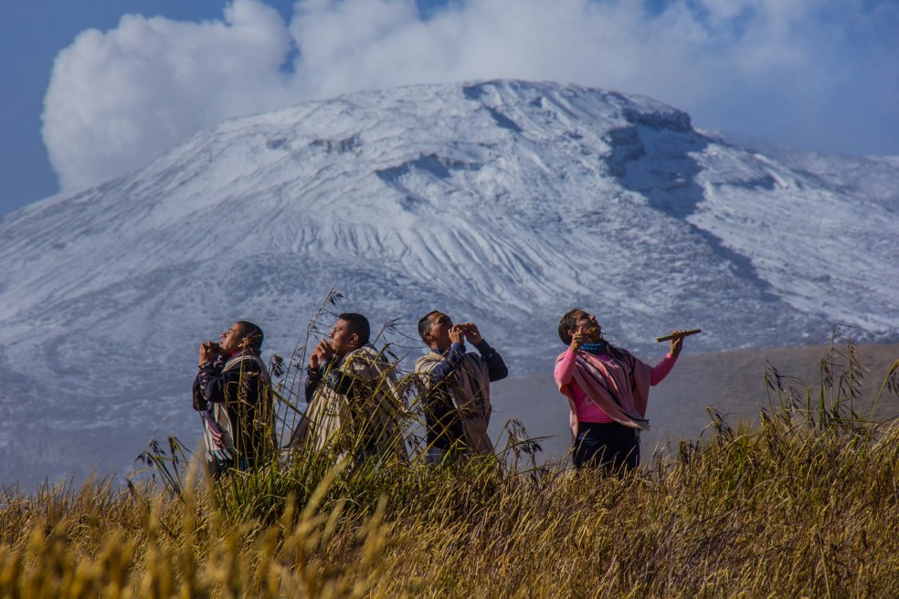 Con viento en el ambiente y una montaña al fondo los Kumba Quimbaya afinan sus instrumentos.