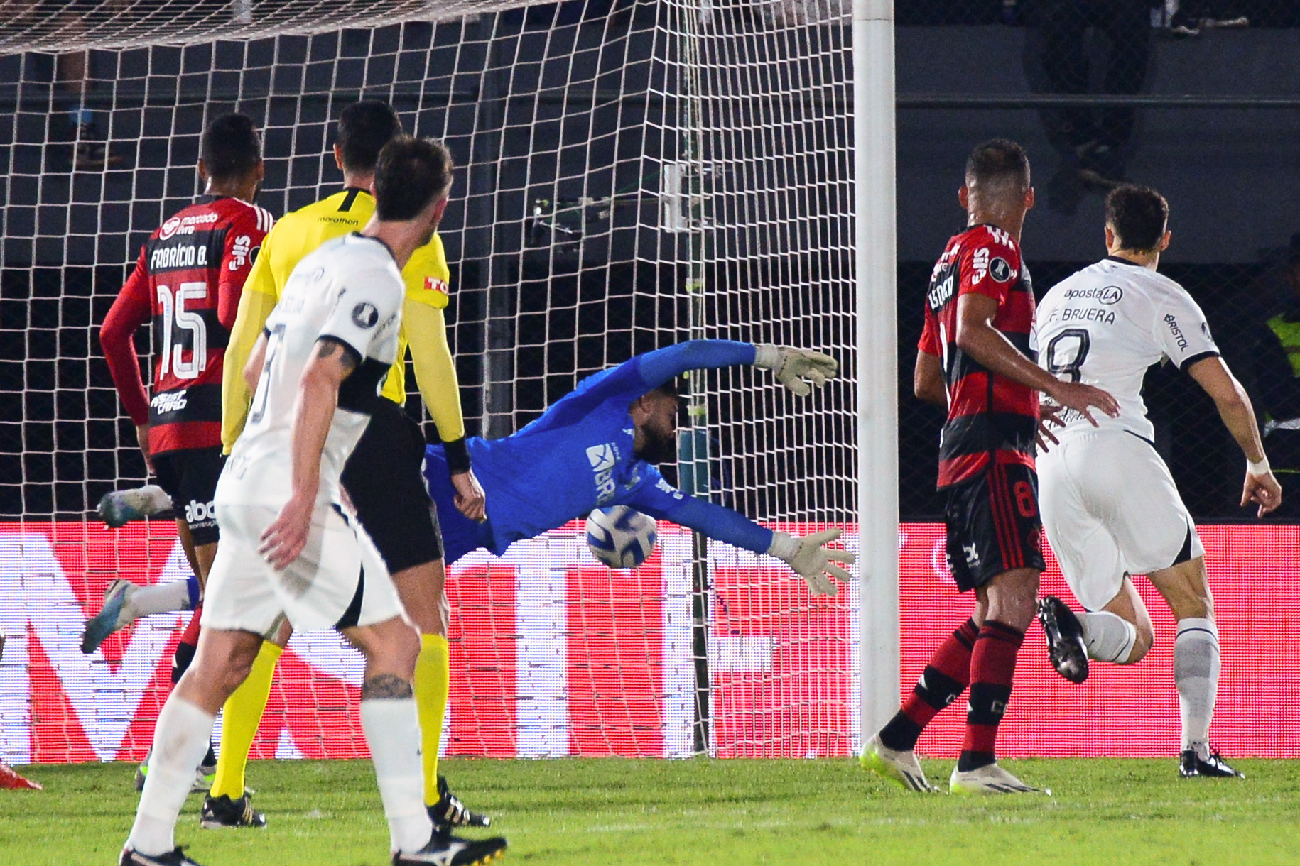 AMDEP8101. ASUNCIÓN (PARAGUAY), 10/08/2023.- Matheus Cunha Queiroz (c) de Flamengo recibe un gol hoy, en un partido de los octavos de final de la Copa Libertadores entre Olimpia y Flamengo en el estadio Defensores del Chaco en Asunción (Paraguay). EFE/ Daniel Piris