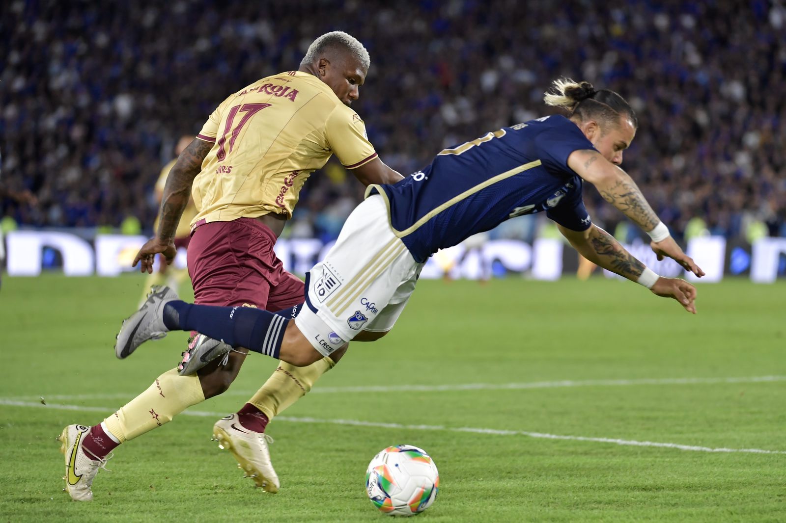El atacante Leonardo Castro (Millonarios) cae tras disputar una pelota con el defensor Marlon Torres (Tolima).