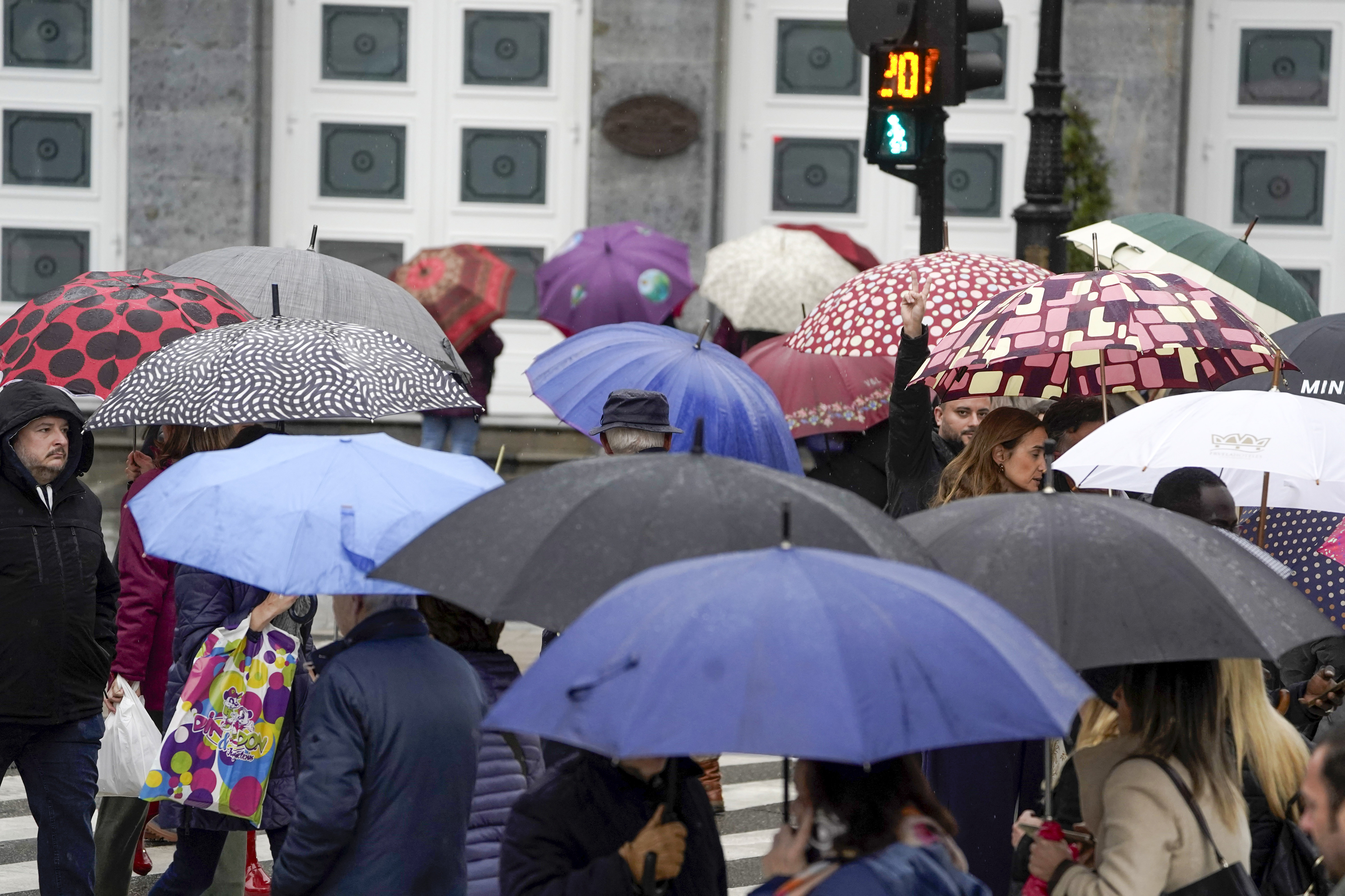 FOTODELDÍA OVIEDO, 03/01/2025.- Paseantes bajo la lluvia en el centro de la ciudad este viernes. La Agencia Estatal de Meteorología pronostica para hoy en Asturias precipitaciones débiles y moderadas, cota de nieve que ascenderá de los 1.700 a los 2.400 metros con temperaturas mínimas en aumento y máximas con cambios ligeros predominando los descensos en el tercio oriental. EFE/Paco Paredes