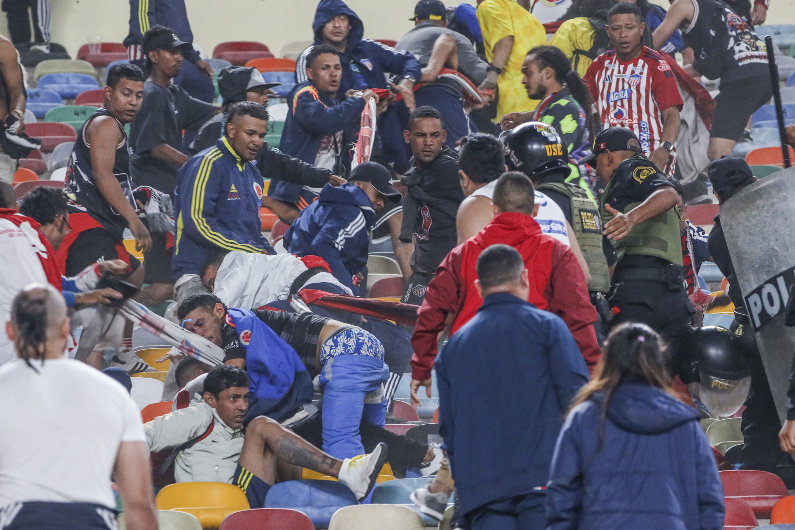 AMDEP1141. LIMA (PERÚ), 07/05/2024.- Hinchas de Junior se enfrentan con integrantes de la Policía de Perú este martes, en un partido de la fase de grupos de la Copa Libertadores entre Universitario y Junior en el estadio Monumental U Marathon, en Lima (Perú). EFE/ Aldair Mejía