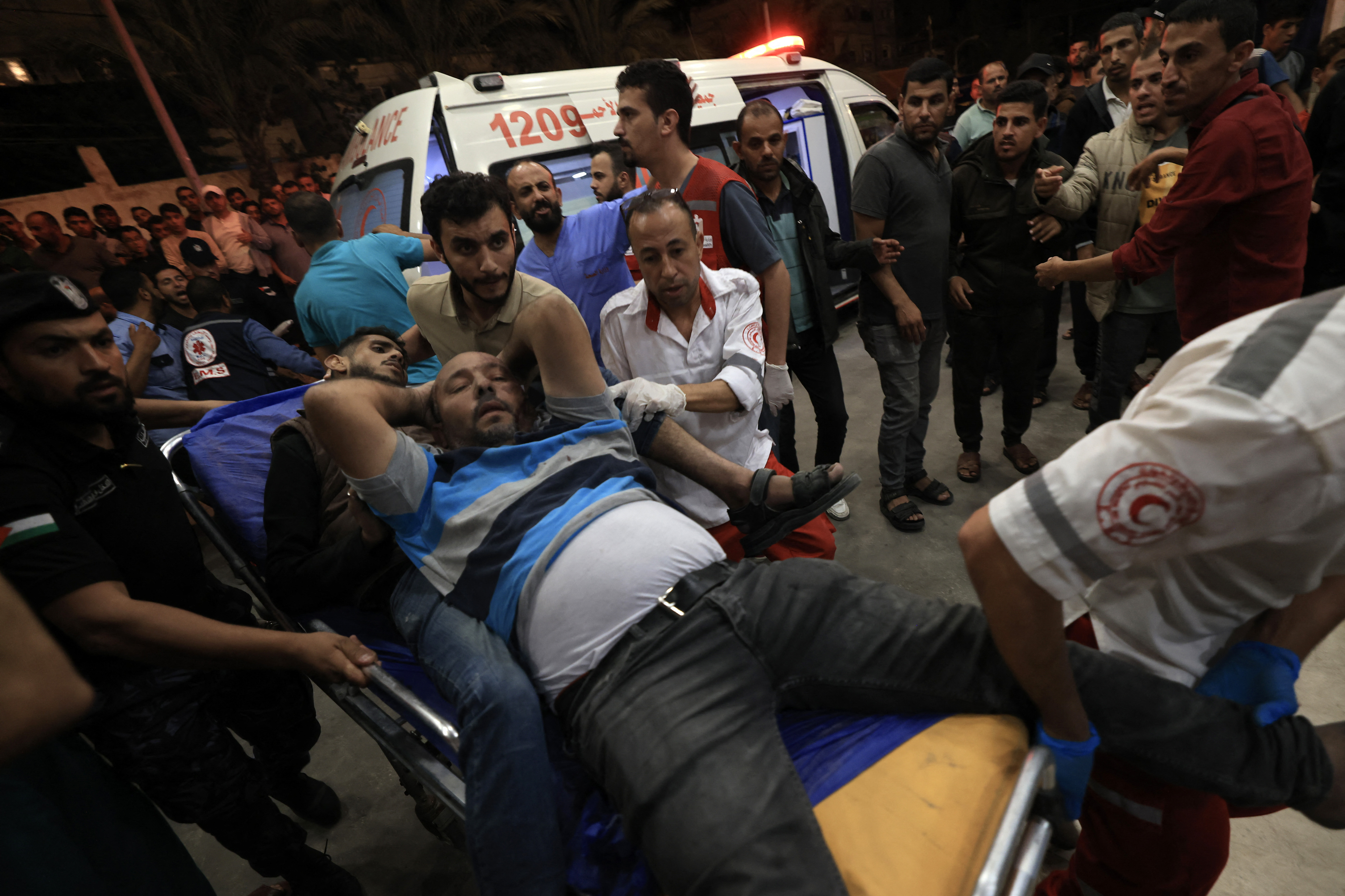 EDITORS NOTE: Graphic content / Two injured men are rushed to a hospital following an Israeli strike on Khan Yunis in the southern Gaza Strip on October 14, 2023. Thousands of people, both Israeli and Palestinians have died since October 7, 2023, after Palestinian Hamas militants based in the Gaza Strip, entered southern Israel in a surprise attack leading Israel to declare war on Hamas in Gaza on October 8. (Photo by Mahmud HAMS / AFP)