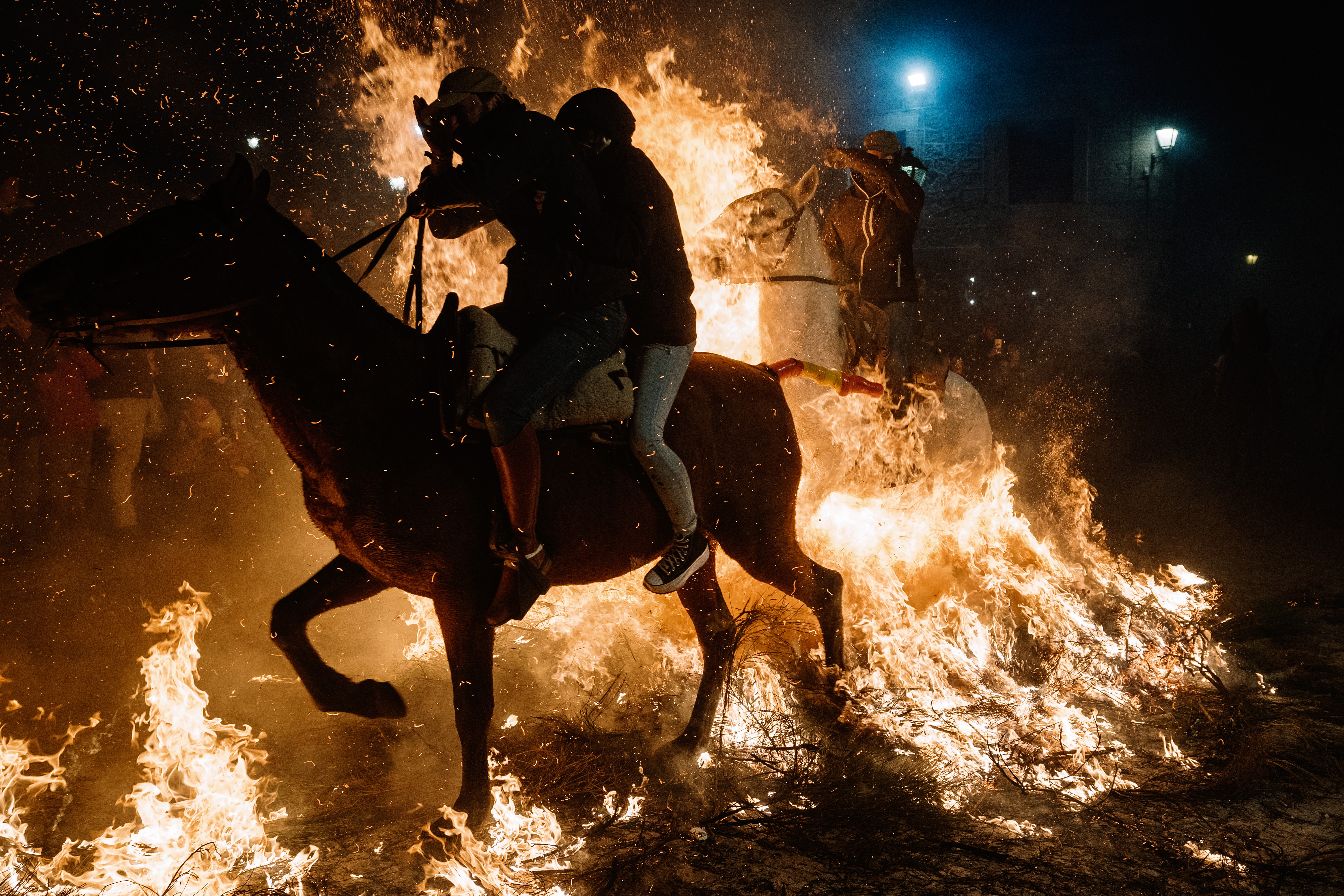 FOTOGALERÍA 7 DE 10.- SAN BARTOLOMÉ DE PINARES (ÁVILA), 16/01/2023.- Un jinete pasa con su caballo por encima de las llamas durante las tradicionales "luminarias" que se celebran hoy lunes en la localidad abulense de San Bartolomé de Pinares. EFE / Raúl Sanchidrián.