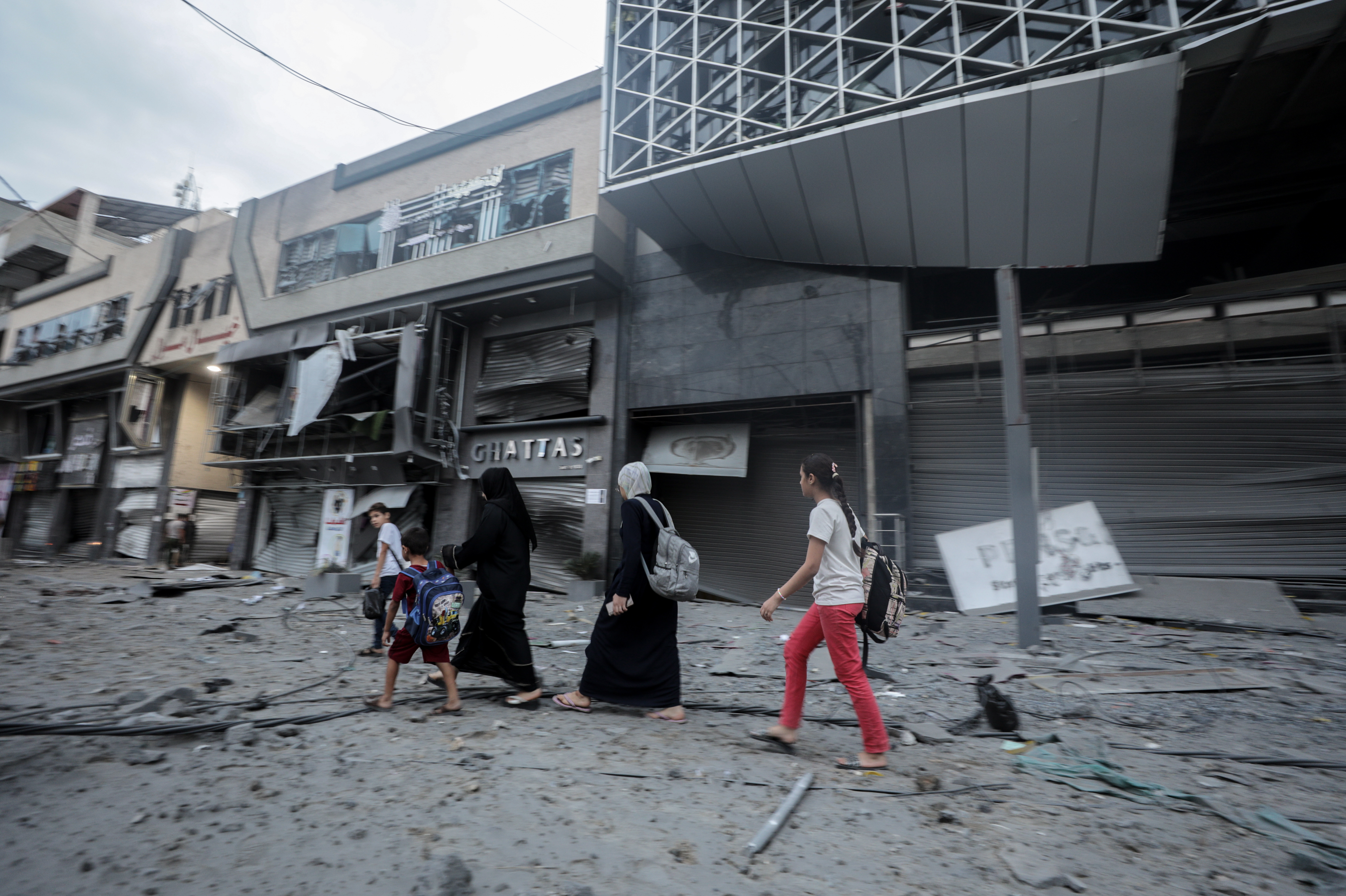 Gaza City (-), 08/10/2023.- Palsetinians walk in debris in the surrounding of the destroyed National Bank building following Israeli air strikes, in Gaza City, 08 October 2023. The air strikes in retaliation for the 07 October Hamas rocket attacks on Israel, have killed over 300 people in the Gaza Strip, with almost 2,000 wounded, according to Palestinian official sources. EFE/EPA/HAITHAM IMAD