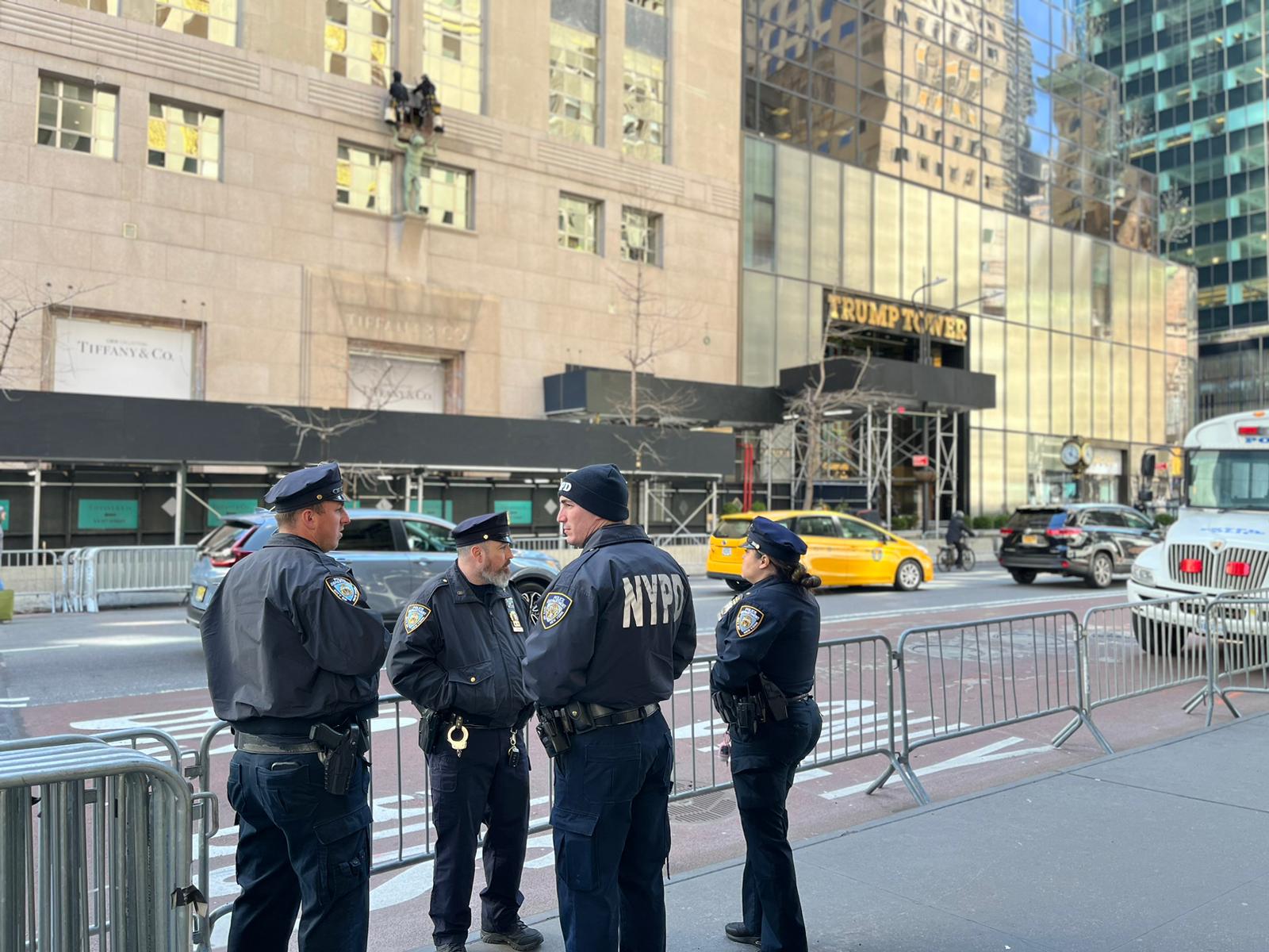 Policías custodian las afueras de la Torre Trump, en la Quinta Avenida, en Nueva York. Según medios de comunicación, el expresidente pasará allí la noche, por lo que el lugar se encuentra rodeado de autobuses de la policía en alerta máxima en previsión de posibles disturbios.