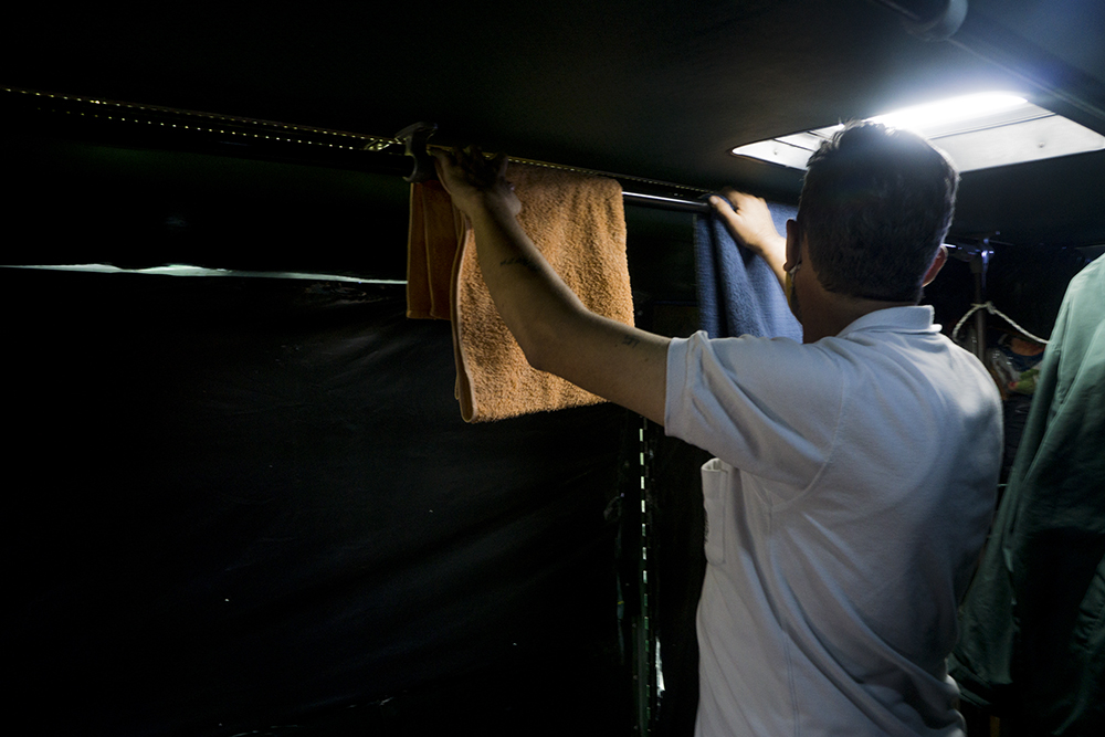 Sus toallas, su ropa y otros menesteres los arrumó en la parte de atrás del vehículo. Las ventanas las tapó con bolsas negras para que la luz no fuera tan intensa para sus ojos y, además, le asegurara un poco de privacidad.