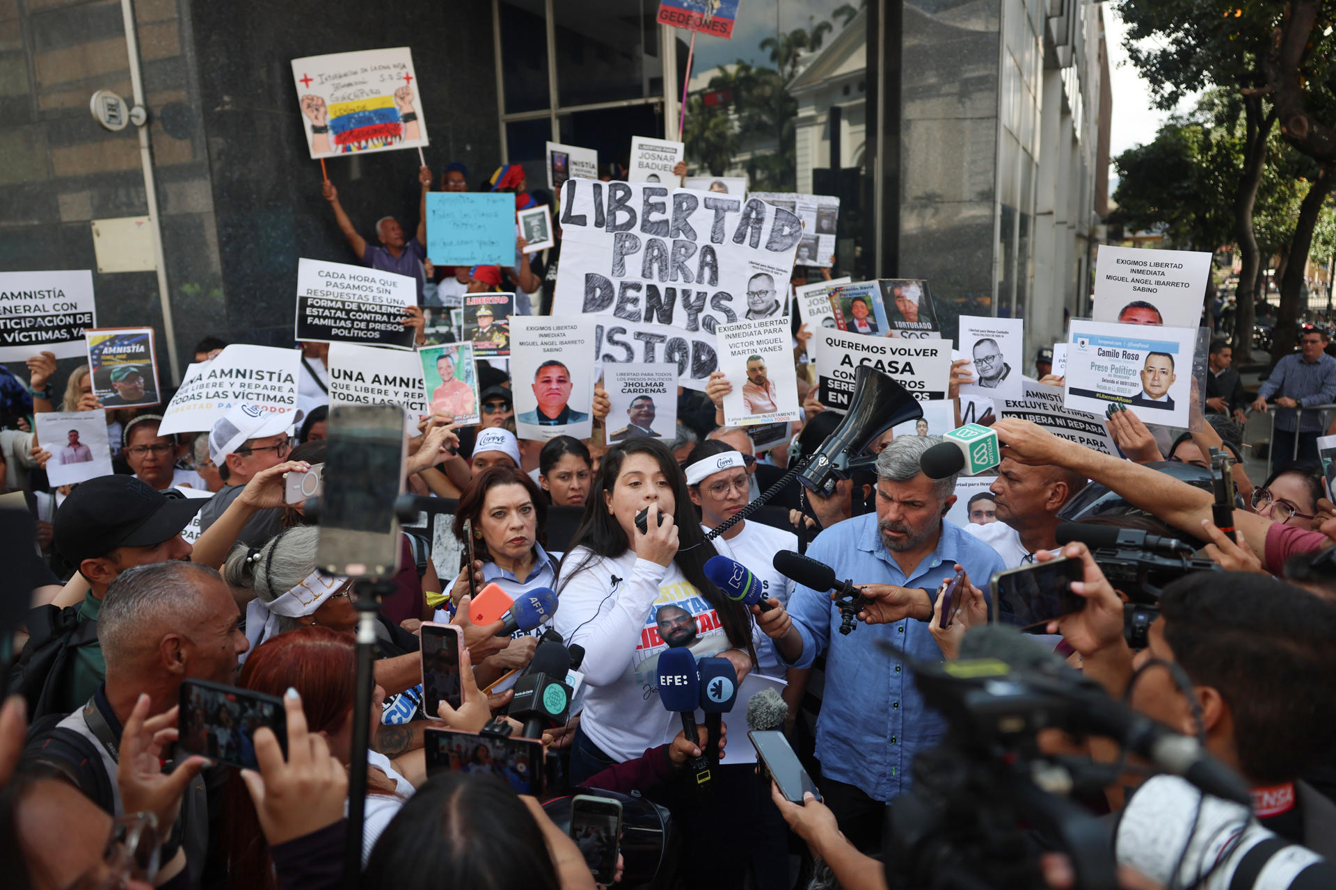 FOTODELDÍA AME3760. CARACAS (VENEZUELA), 10/02/2026.- La activista Andreína Baduel (c) habla en una manifestación durante la Asamblea Nacional sobre la Ley de Amnistía este martes, en Caracas (Venezuela). Familiares de presos políticos en Venezuela advirtieron este martes que "más de la mitad" de los detenidos estarían excluidos del proyecto de ley de amnistía, aprobado por el Parlamento en primera discusión y en proceso de consulta pública para su segundo debate y aprobación definitiva. EFE/ Miguel Gutiérrez