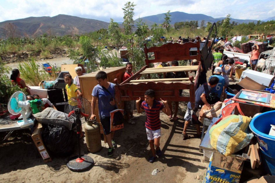 Cientos de colombianos cargan sus pertenencias por el río Tachira desde Venezuela hacia el sector La Parada en Cúcuta. /Agencia EFE