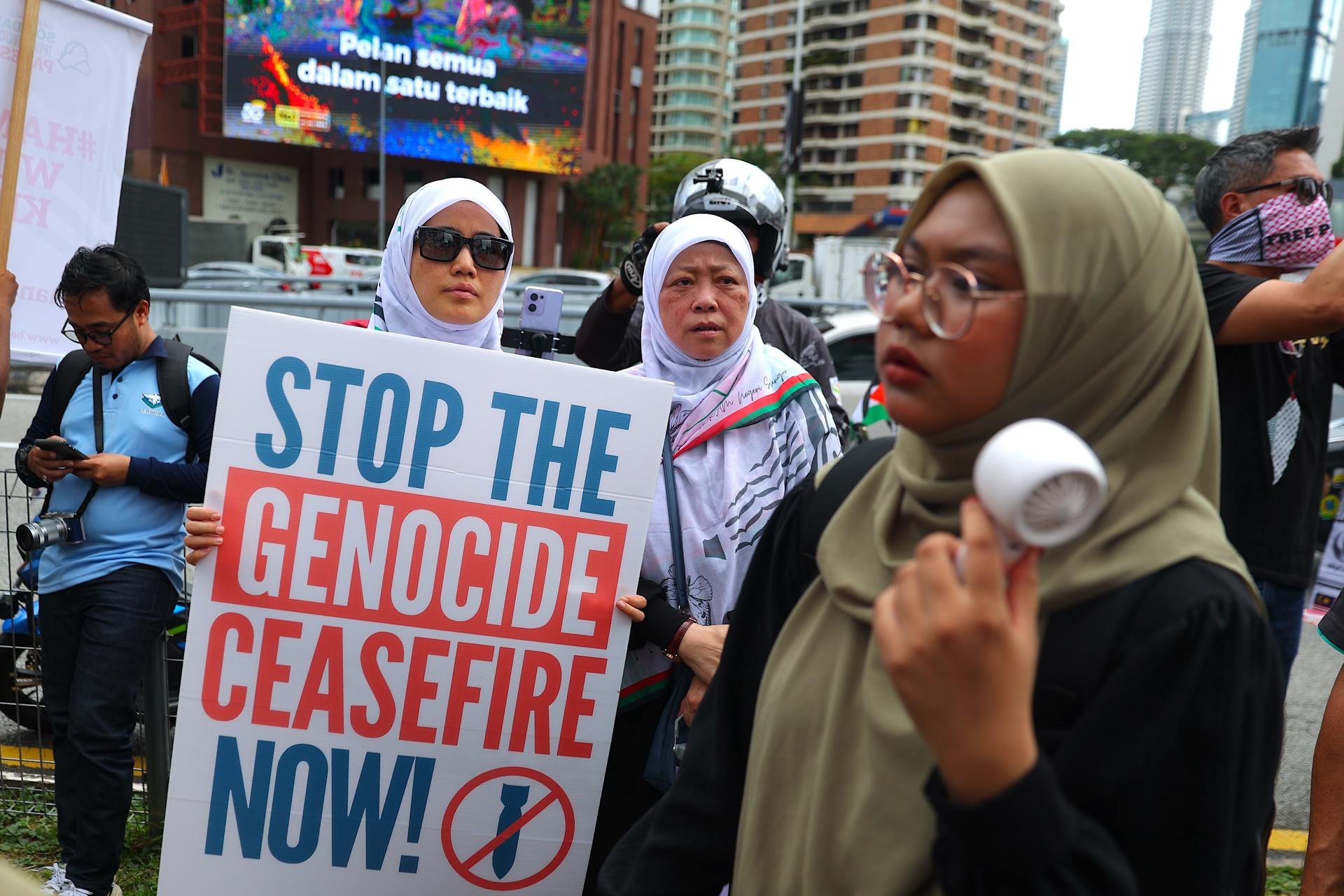 KUALA LUMPUR (Malaysia), 16/05/2025.- A protester holds a placard near the US embassy during the 'Nakba 77 Stop Genocide' gathering in solidarity with the Palestinian people, in Kuala Lumpur, Malaysia, 16 May 2025. Nakba Day (Day of the Catastrophe) is commemorated annually on 15 May to remember their displacement of Palestinians following the 1948 Israeli Declaration of Independence. (Protestas, Malasia) EFE/EPA/FAZRY ISMAIL