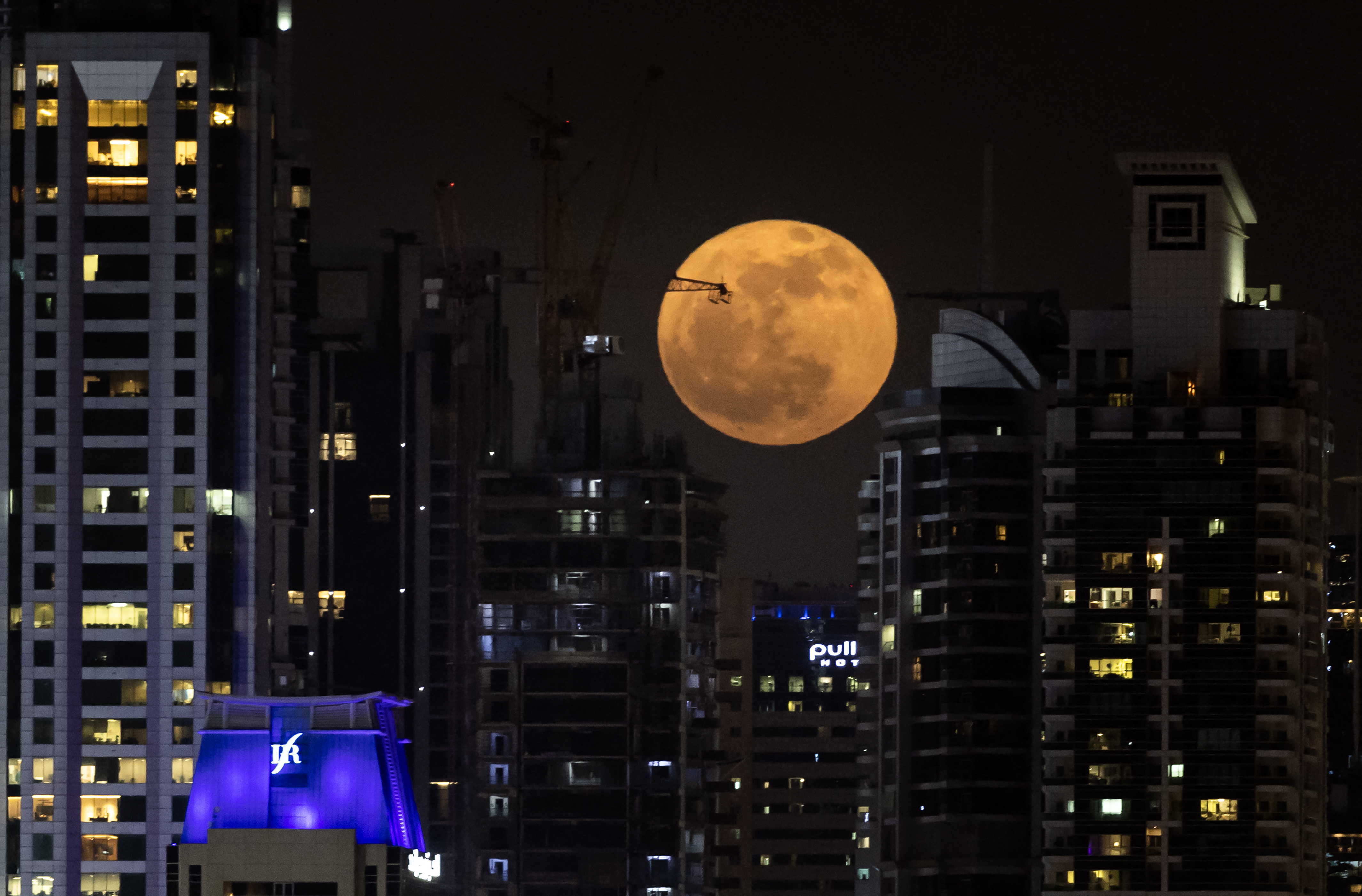 La luna llena, conocida como la «Luna de fresa», se eleva sobre el horizonte de Dubai el 11 de junio de 2025.