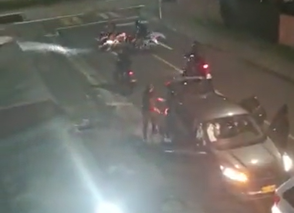 Autos se ven rodeados por motos.