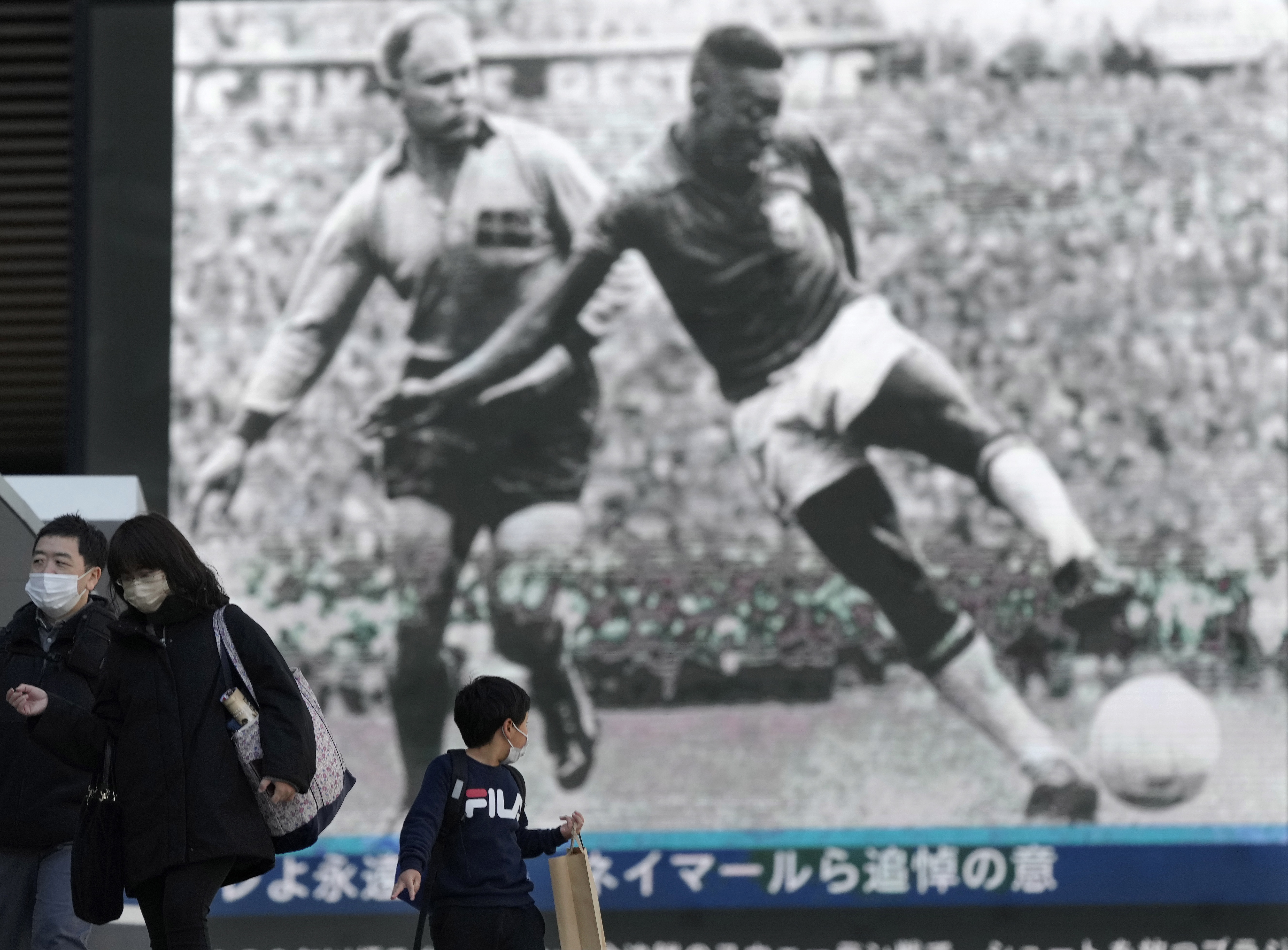 Tokyo (Japan), 30/12/2022.- A boy turns back to look at a huge display showing news of the death of soccer legend Pele in Tokyo, Japan, 30 December 2022. Brazilian soccer legend Pele, born Edson Arantes do Nascimento, died at the age of 82 on 29 December 2022. (Brasil, Japón, Tokio) EFE/EPA/KIMIMASA MAYAMA