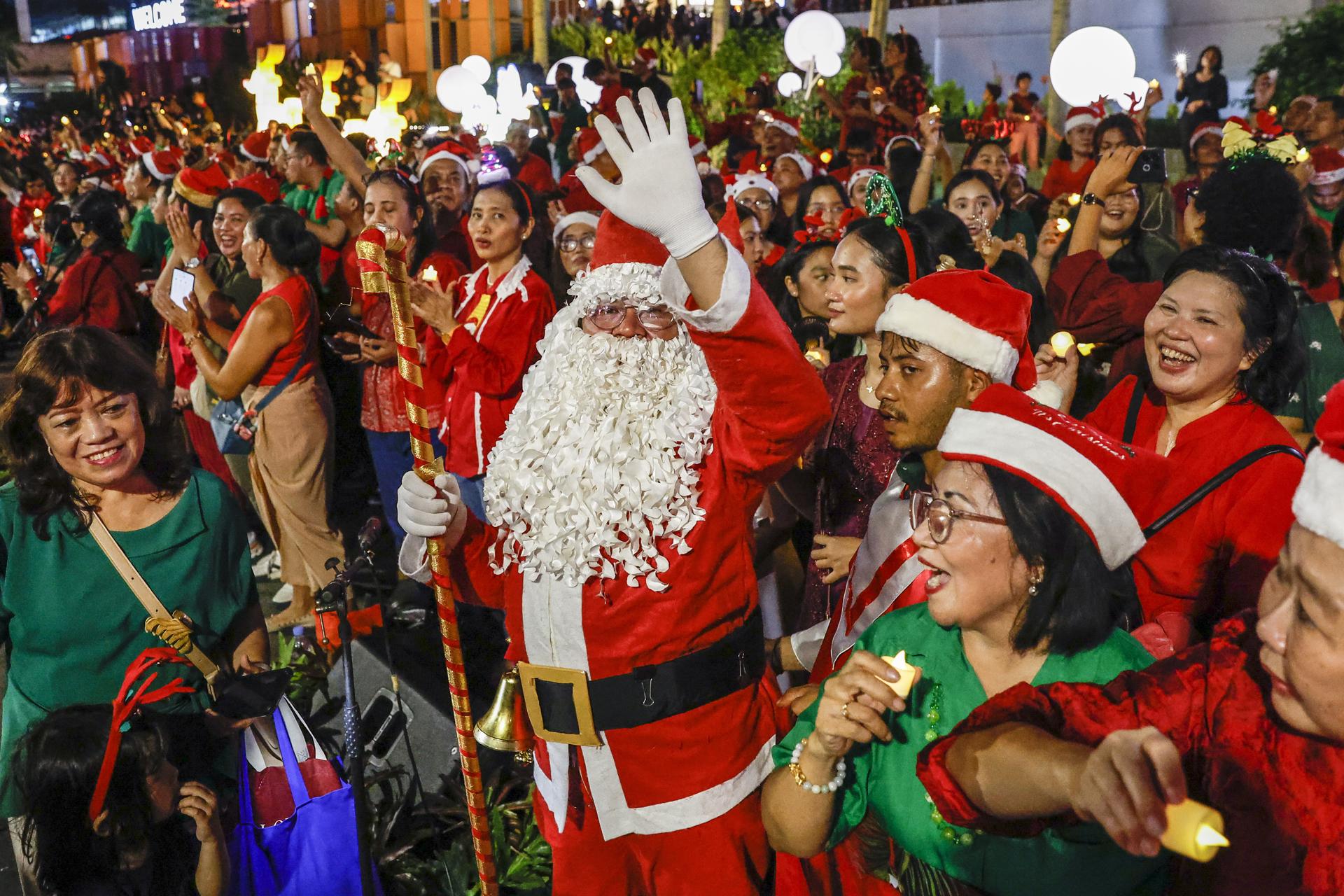 JAKARTA (Indonesia), 23/12/2025.- Choir members gather as they prepare to sing Christmas carols on a sidewalk ahead of Christmas celebrations in Jakarta, Indonesia, 23 December 2025. Although the majority of Indonesians are Muslim, Christmas is widely observed across the country, with many non-Christians celebrating it as a secular holiday. EFE/EPA/MAST IRHAM