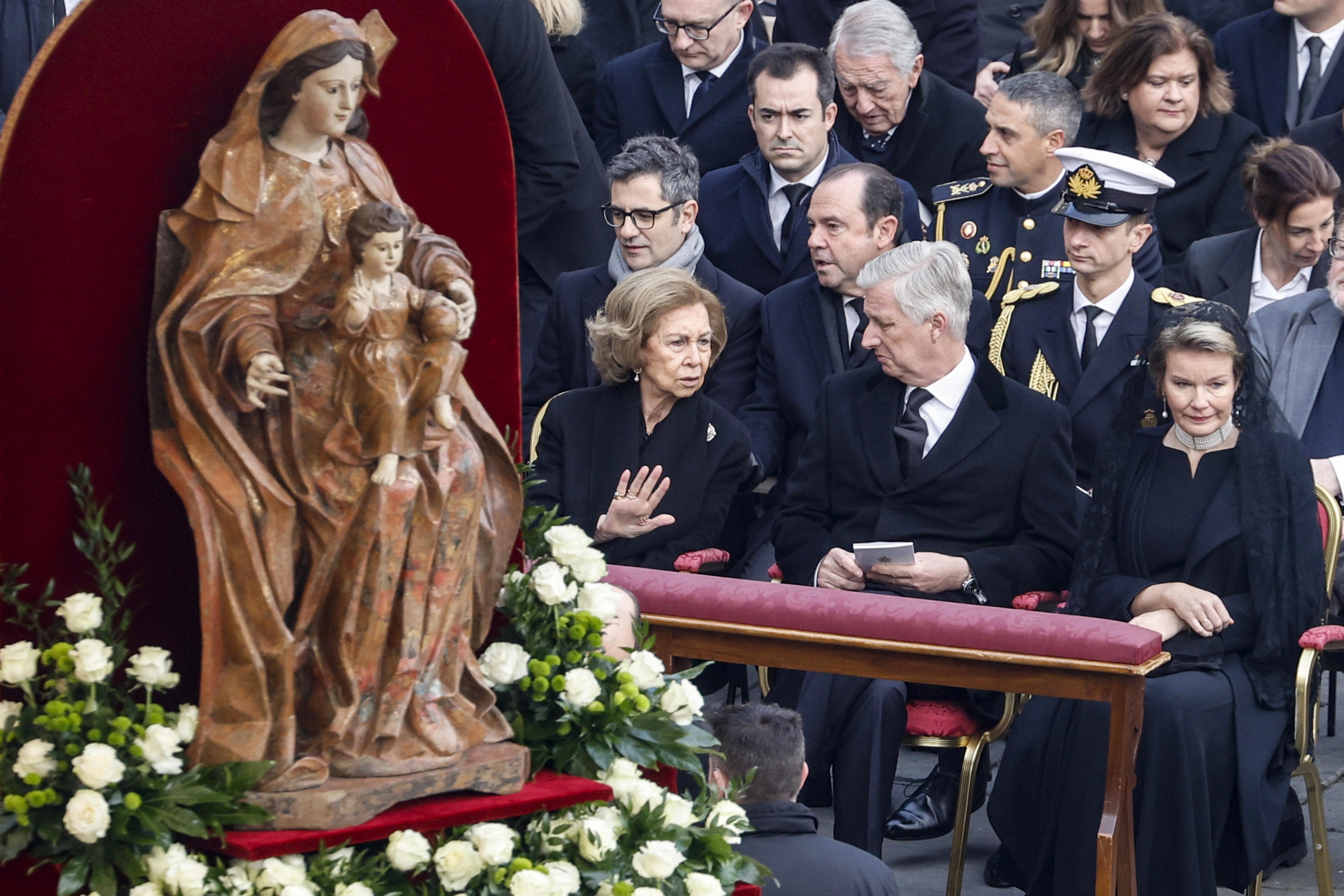 La reina emérita española Sofía (izq.) y el Rey Felipe (centro) de Bélgica hablan durante la ceremonia fúnebre en la plaza de San Pedro.