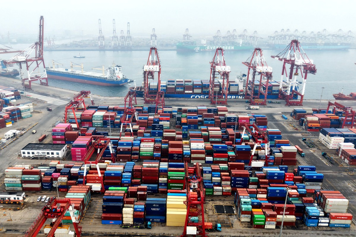 Cargo containers and ships are seen at a port in Qingdao, in China's eastern Shandong province, on March 3, 2026. (Photo by CN-STR / AFP) / China OUT / CHINA OUT