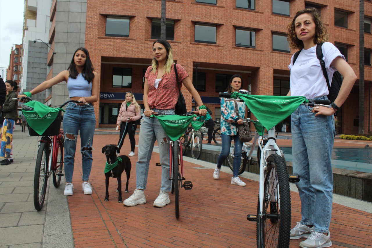 Tres mujeres y un perro al lado de sus bicicletas