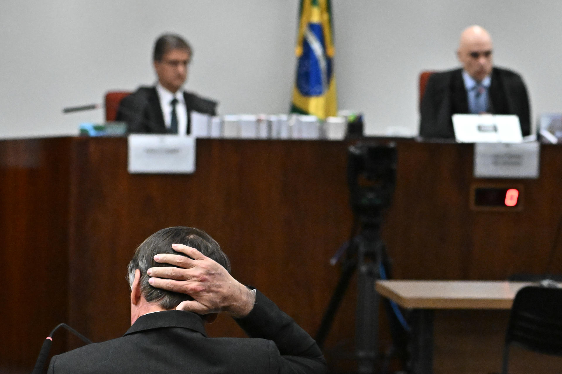 AME4518. BRASILIA (BRASIL), 09/06/2025.- El juez relator de la Suprema Corte de Brasil, Alexandre de Moraes (d), el Fiscal General, Paulo Gonet (i), y el expresidente de Brasil, Jair Bolsonaro (abajo) participan en la sesión de interrogatorio ante el Tribunal Supremo este lunes, en Brasilia (Brasil). La Corte Suprema de Brasil empezó a interrogar a Mauro Cid, antiguo ayudante personal de Bolsonaro y pieza clave de la acusación contra el líder ultraderechista por planear un intento de golpe de Estado para mantenerse en el poder.EFE/ Andre Borges
