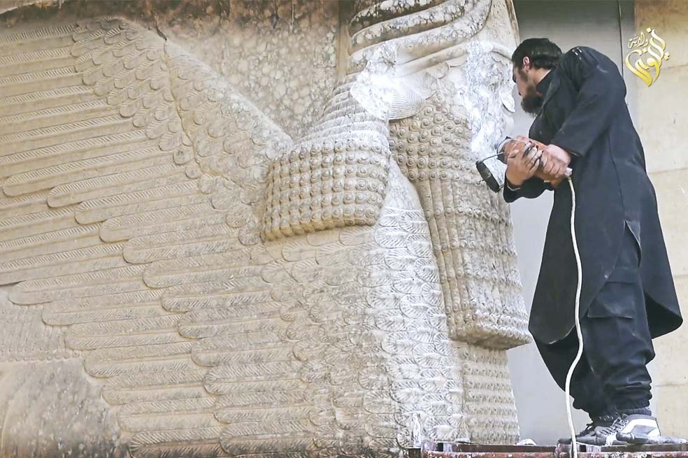 Un militante del EI destruye la estatua de Lamasu, una deidad asiria. / AFP