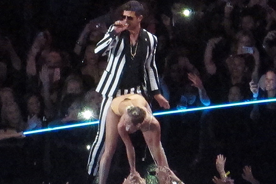 Miley Cyrus twerks on Robin Thick onstage at VMA's while his wife, Paula Patton (black dress with high slit in leg) cheers them on from the celebrity row as she watches the now infamous dance number. The act was performed during the 2013 Video Music Awards held at the Barclay's Center in Brooklyn, New York. Miley showed off her dance moves to the fans and even put a foam finger in her crotch while Robin continued the rest of the dance number alone leaving Miley by the band. She was seen on video making a gesture at the crowd as he wrapped up the performance solo. Video to follow
<P>
Pictured: Miley Cyrus, Robin Thicke
<B>Ref: SPL593659 250813 </B><BR/>
Picture by: Brian Prahl / Splash News<BR/>
</P><P>
<B>Splash News and Pictures</B><BR/>
Los Angeles:310-821-2666<BR/>
New York:212-619-2666<BR/>
London:870-934-2666<BR/>
photodesk@splashnews.com<BR/>
</P>